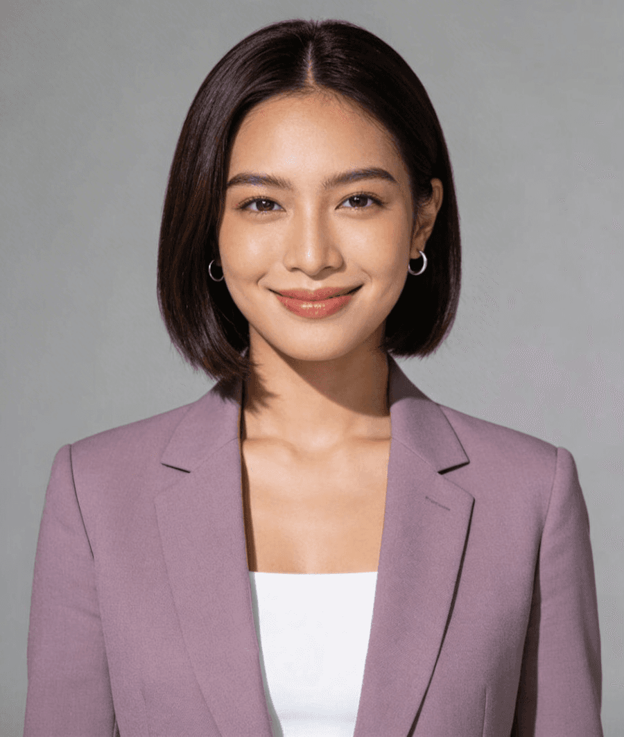 Smiling professional woman in mauve blazer, studio portrait