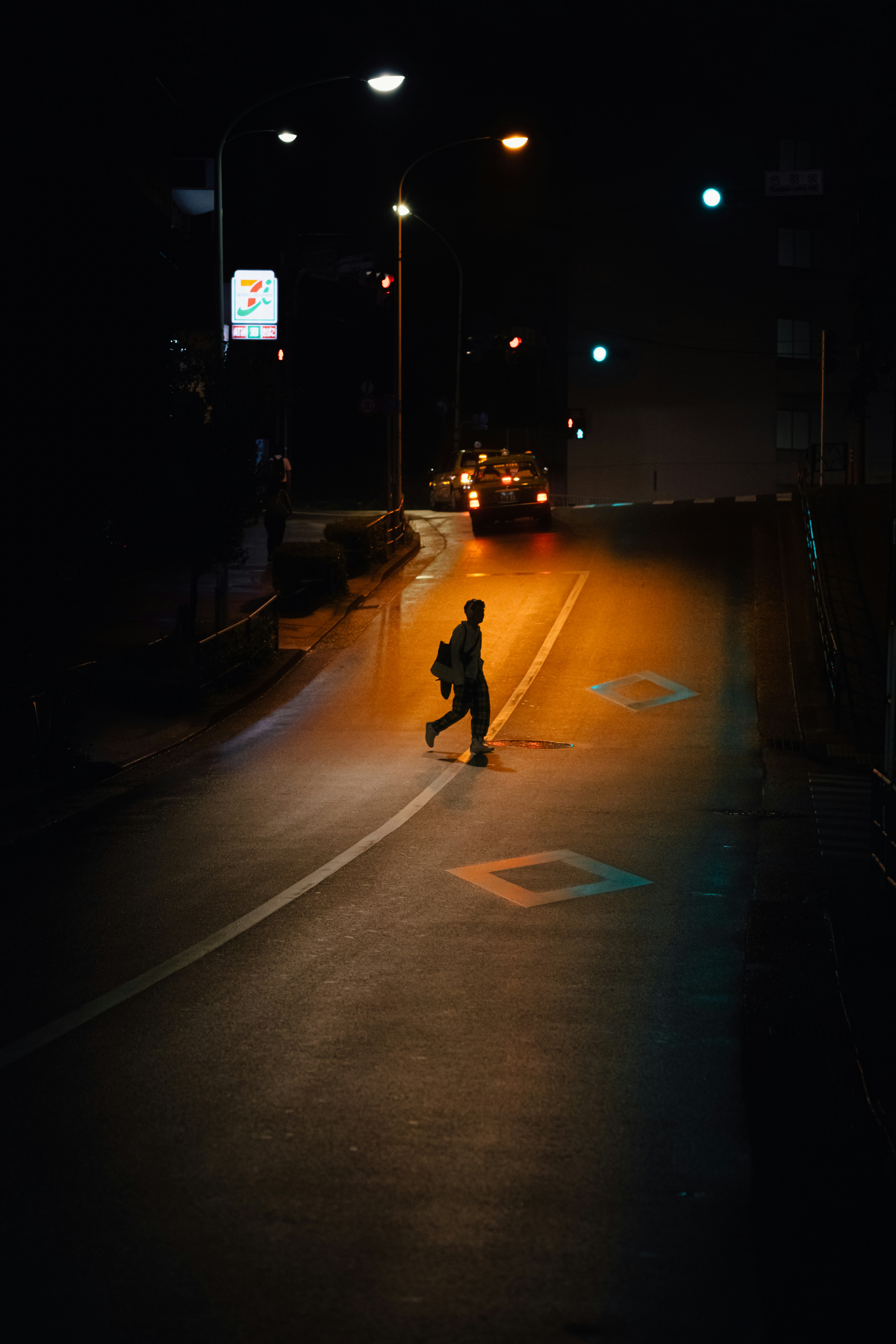 Person walking across road at night