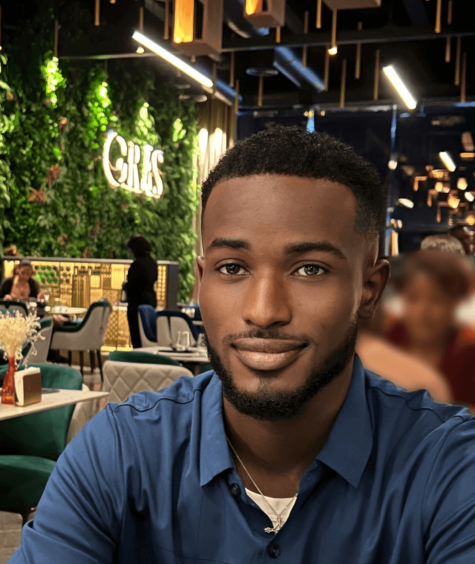Woman working on a laptop computer at a table in a bright room.