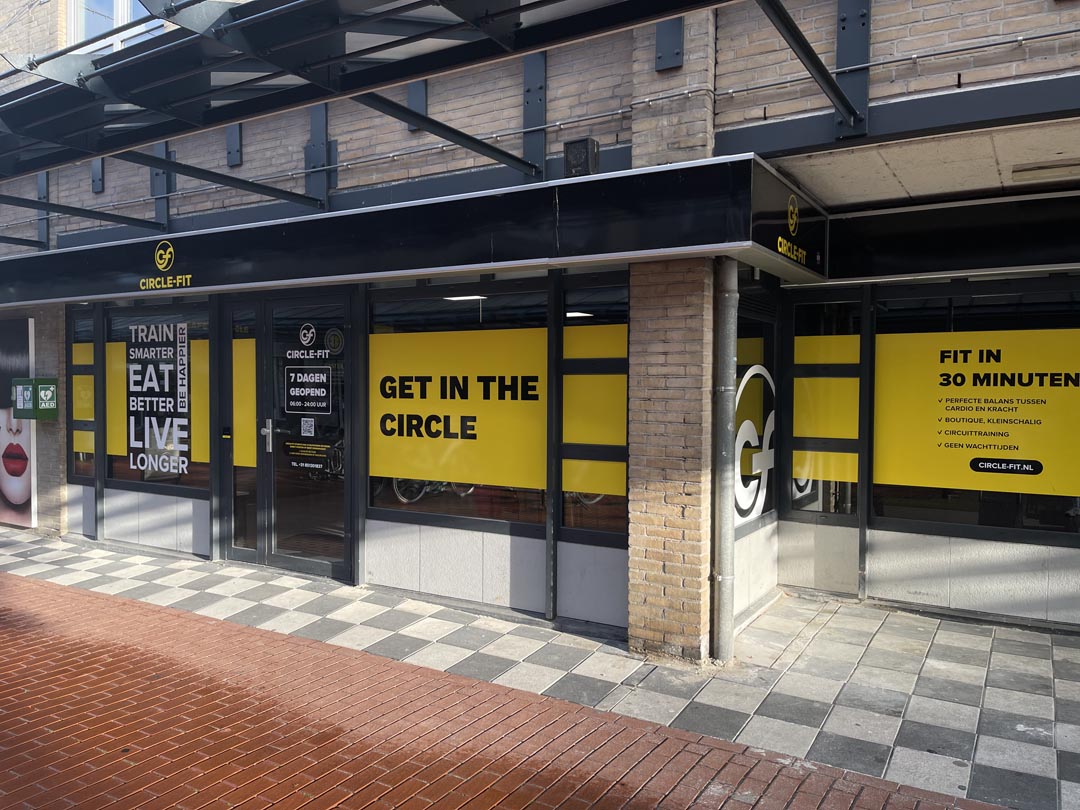 A Circle Fit hub with large yellow signage and modern architectural elements, set in an urban environment.