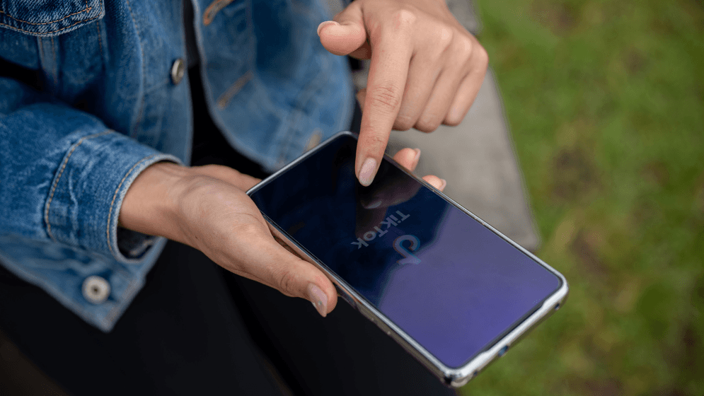 Seorang wanita Malaysia menggunakan TikTok di telefonnya.