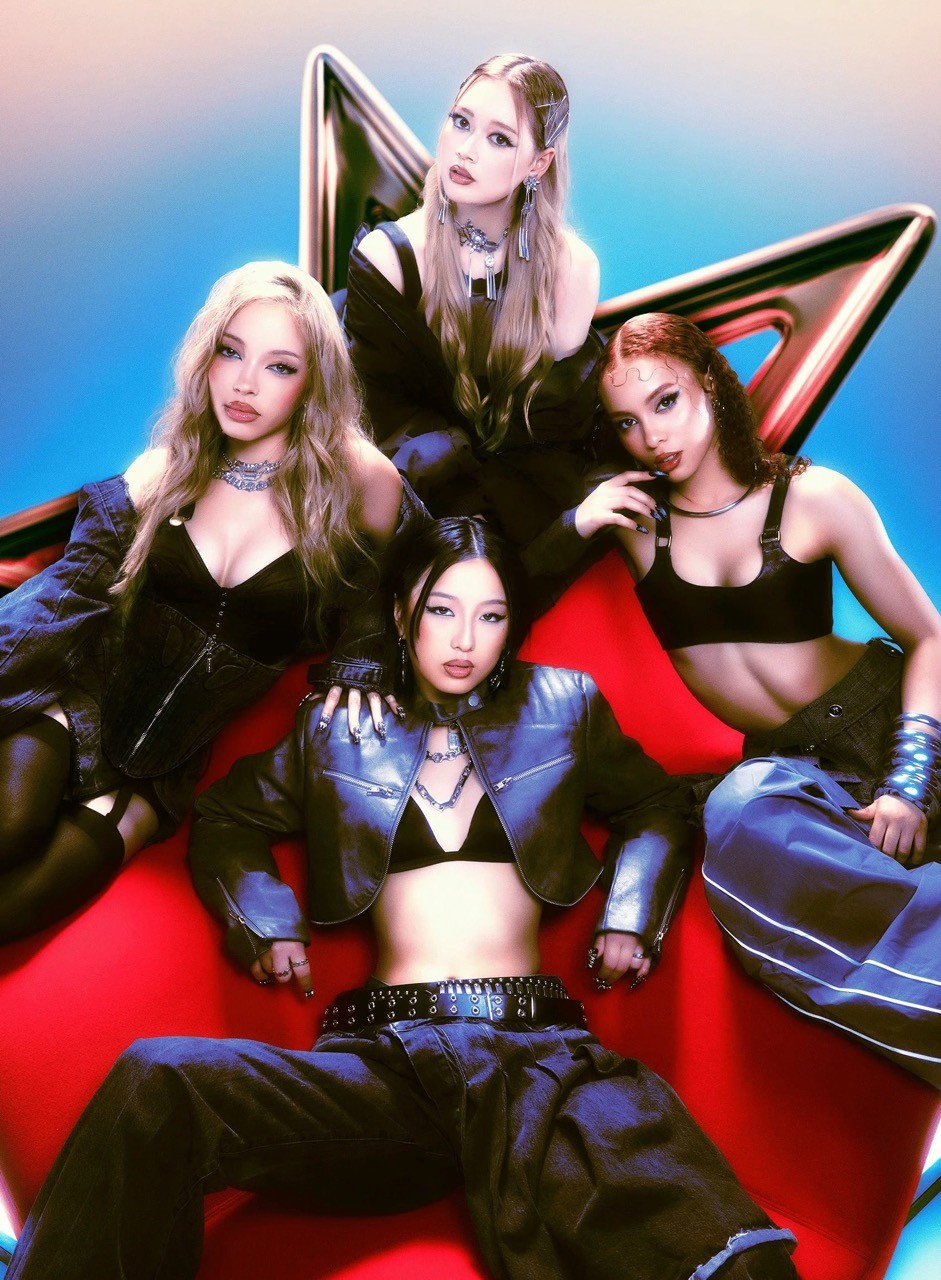 GIRLSET members (Lexi, Camila, Kendall, and Savanna) posing for a Y2K themed photoshoot, in dark clothing on a red surface.