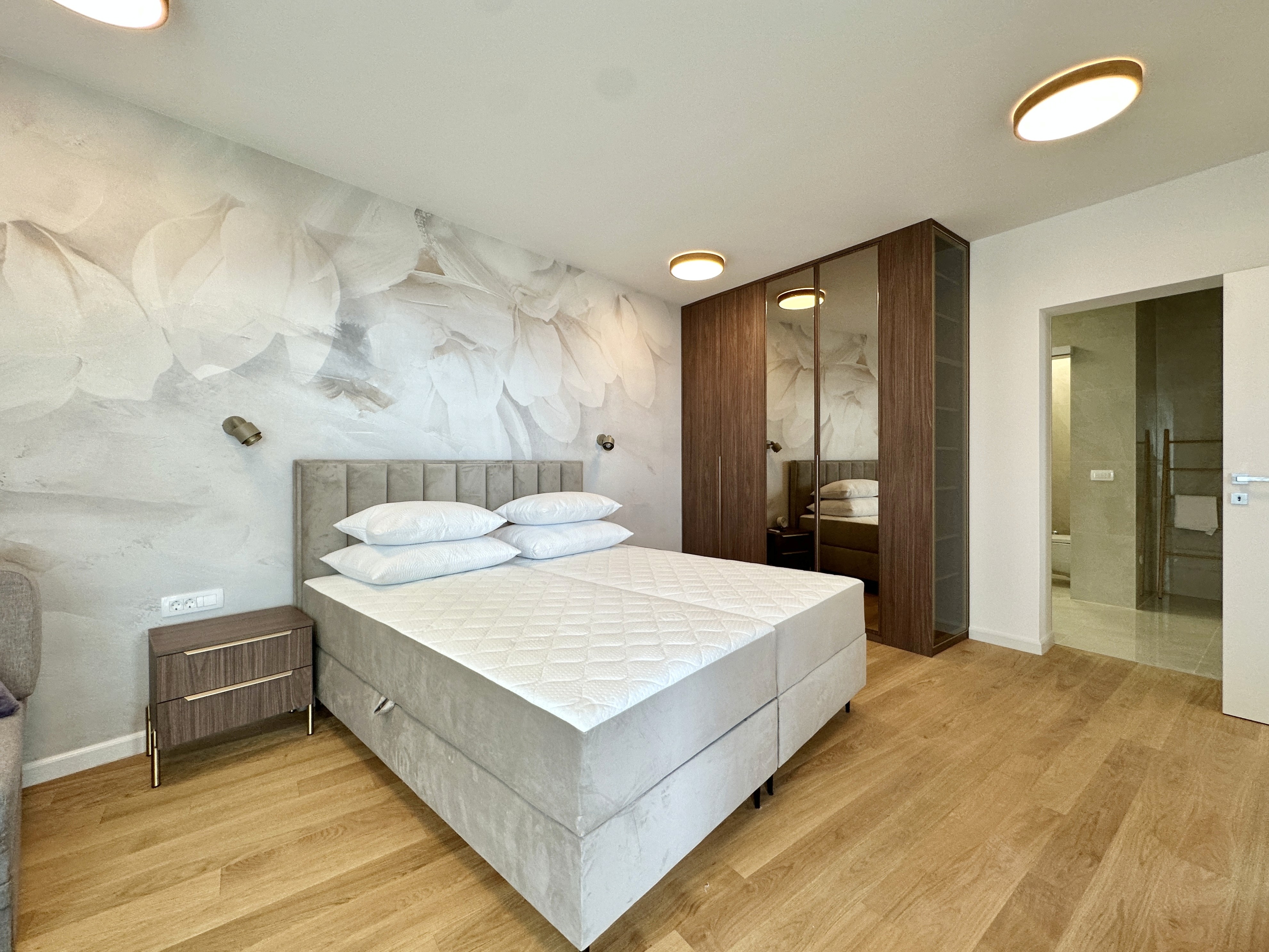 Sleek silver sports car parked next to a modern illuminated pool