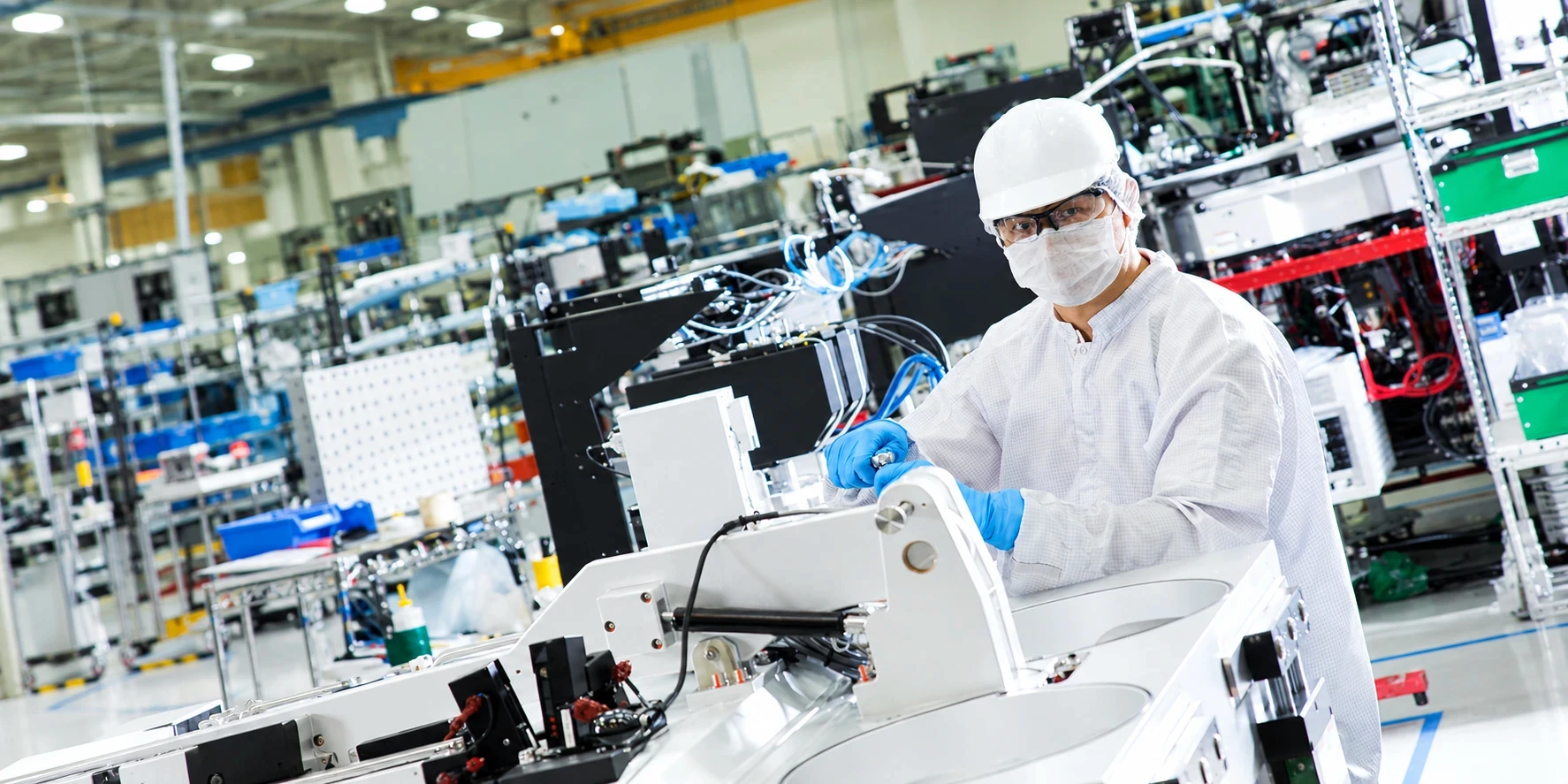 Engineer assembling semiconductor equipment in a cleanroom