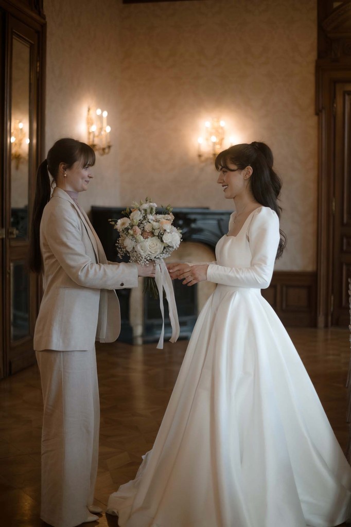 Hochzeitsplanerin Emily übergibt der Braut ihren Brautstrauß.