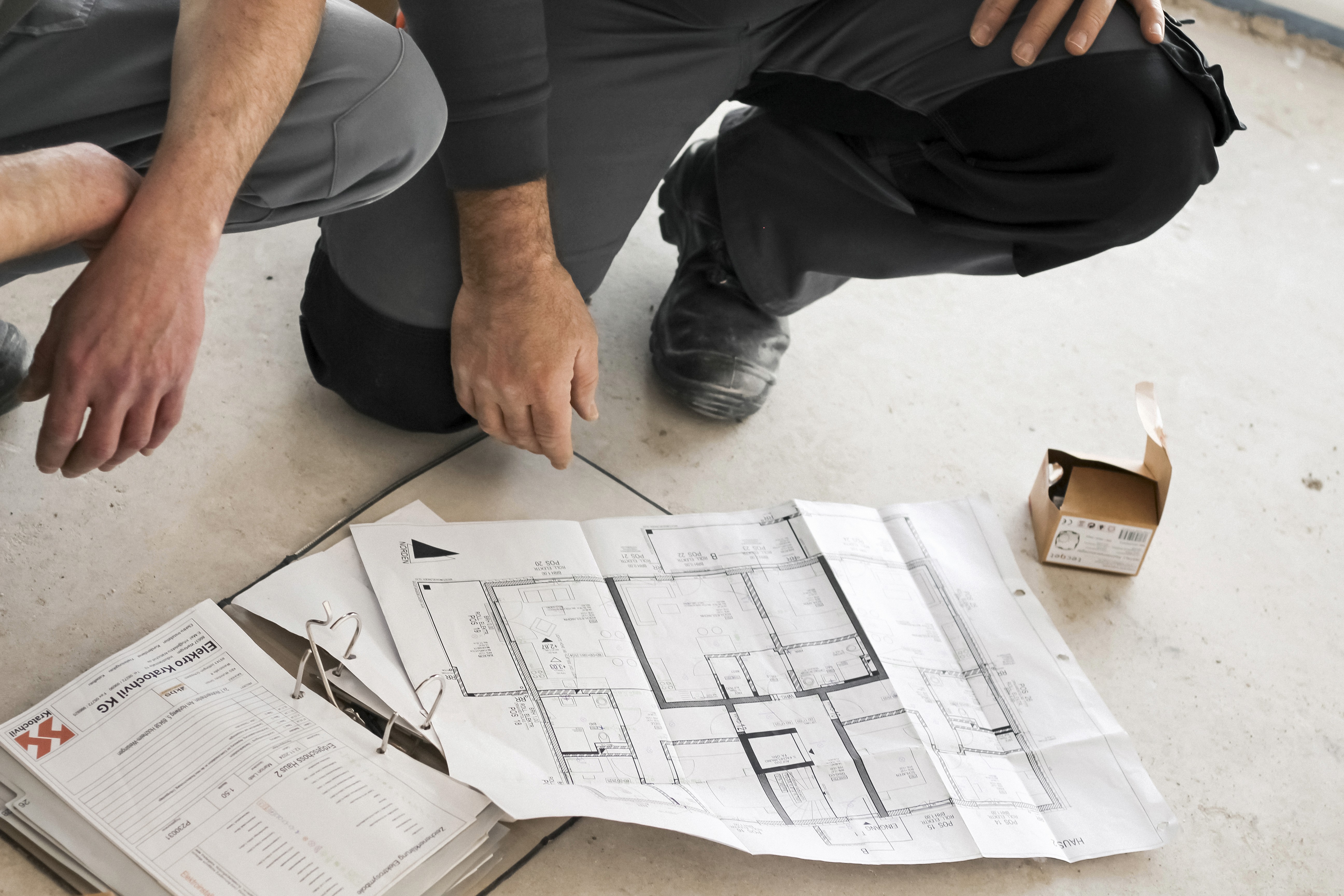 Arbeiter von Elektro Kratochvil besprechen Baupläne für die Elektroinstallation