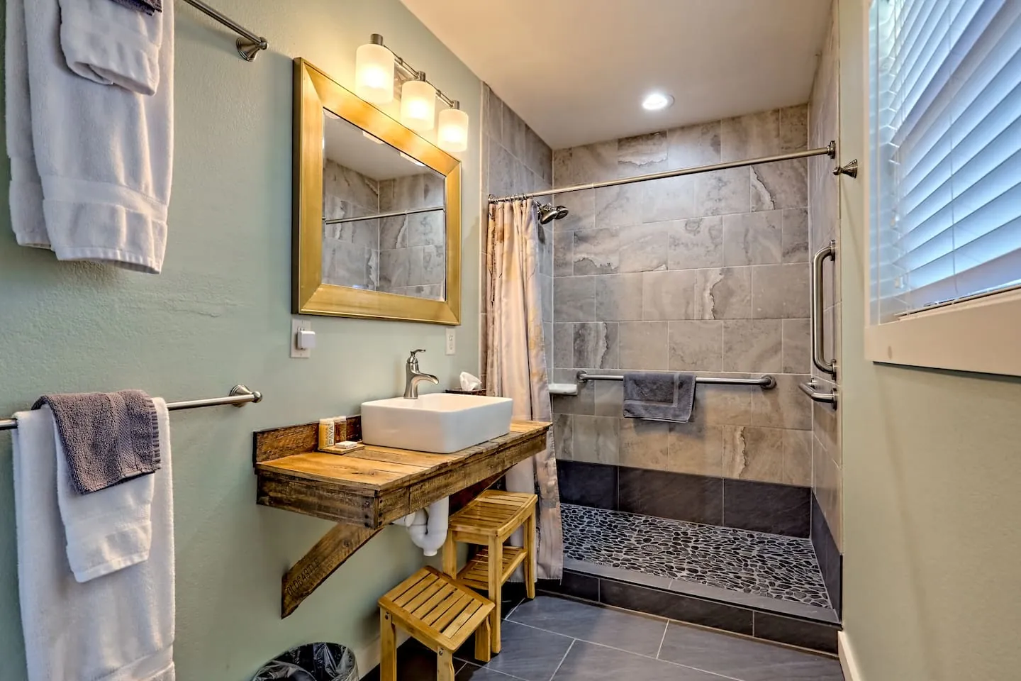 Eagles Nest roll-in tiled shower with grab bars and a shower bench