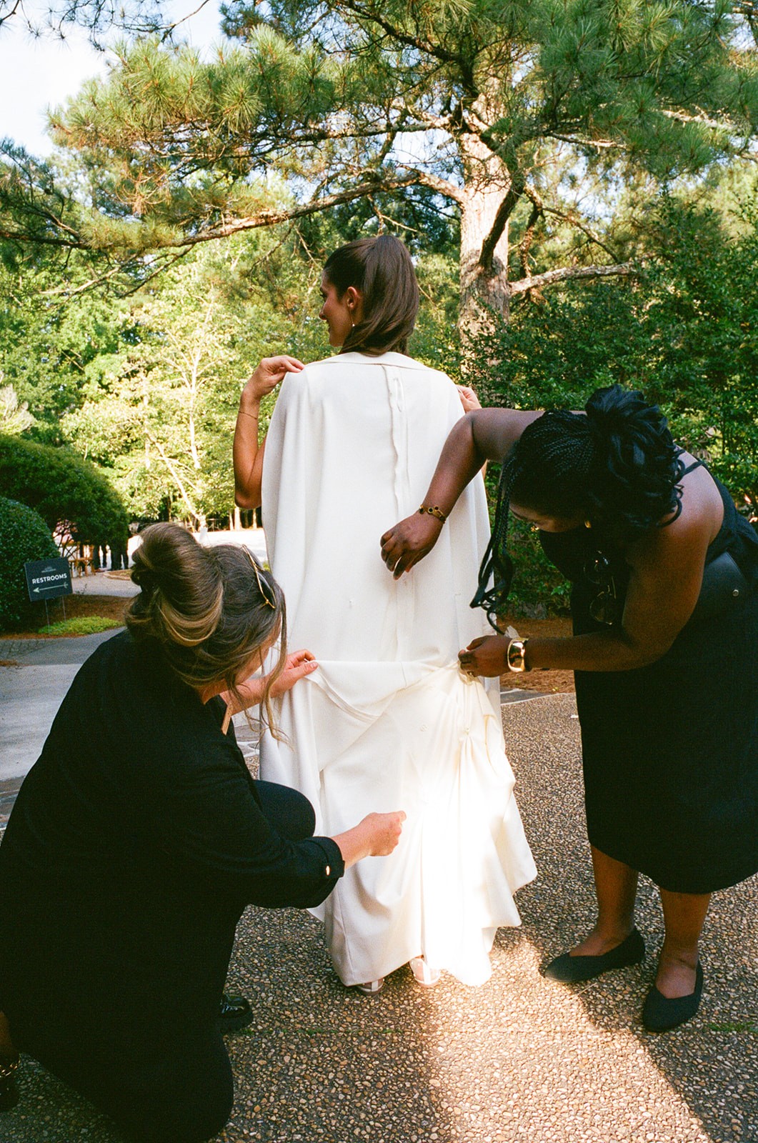 Attendants adjusting Paige’s wedding dress before the ceremony.