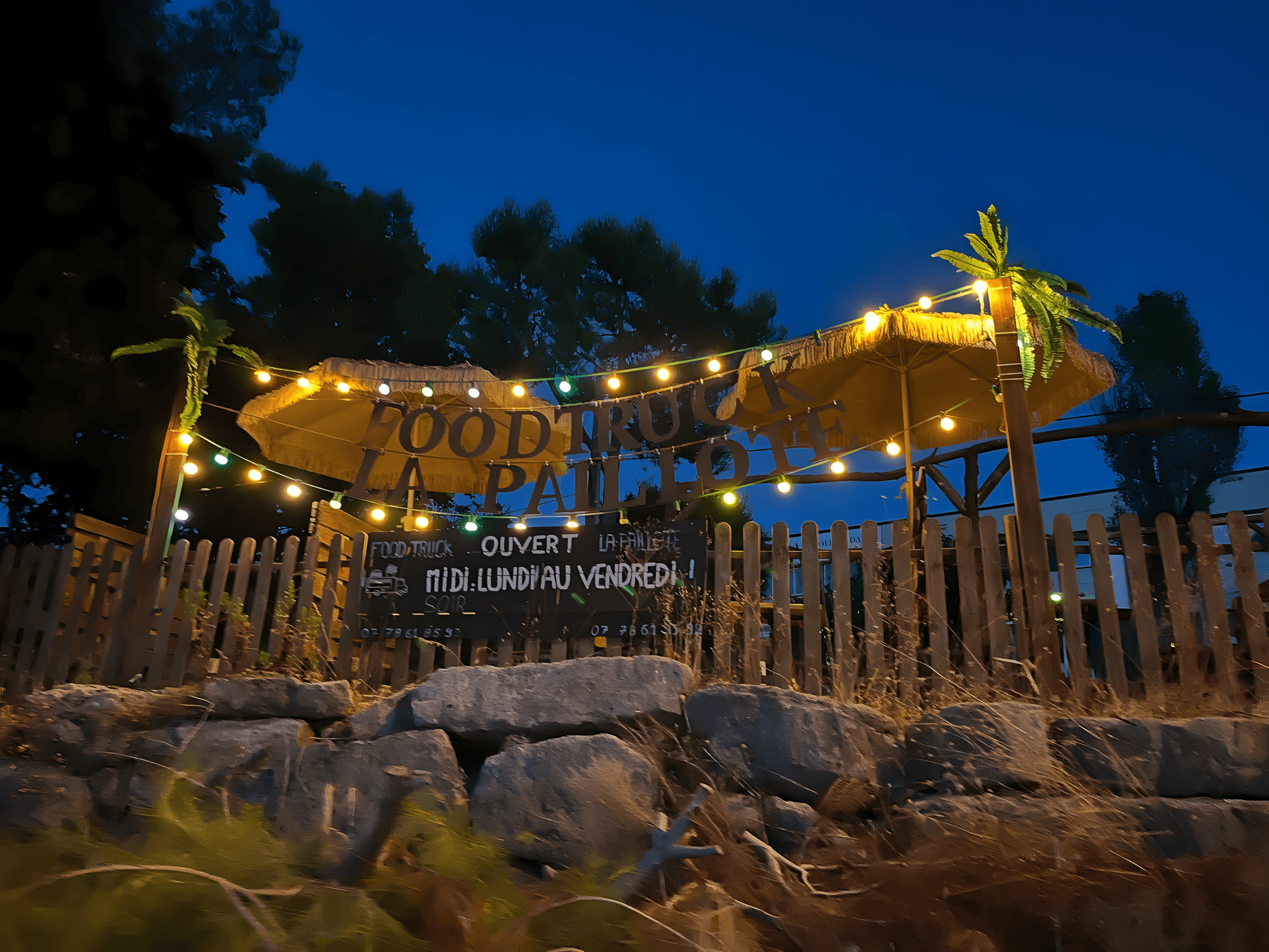 Terrasse du foodtruck, de nuit, avec un éclairage chaleureux