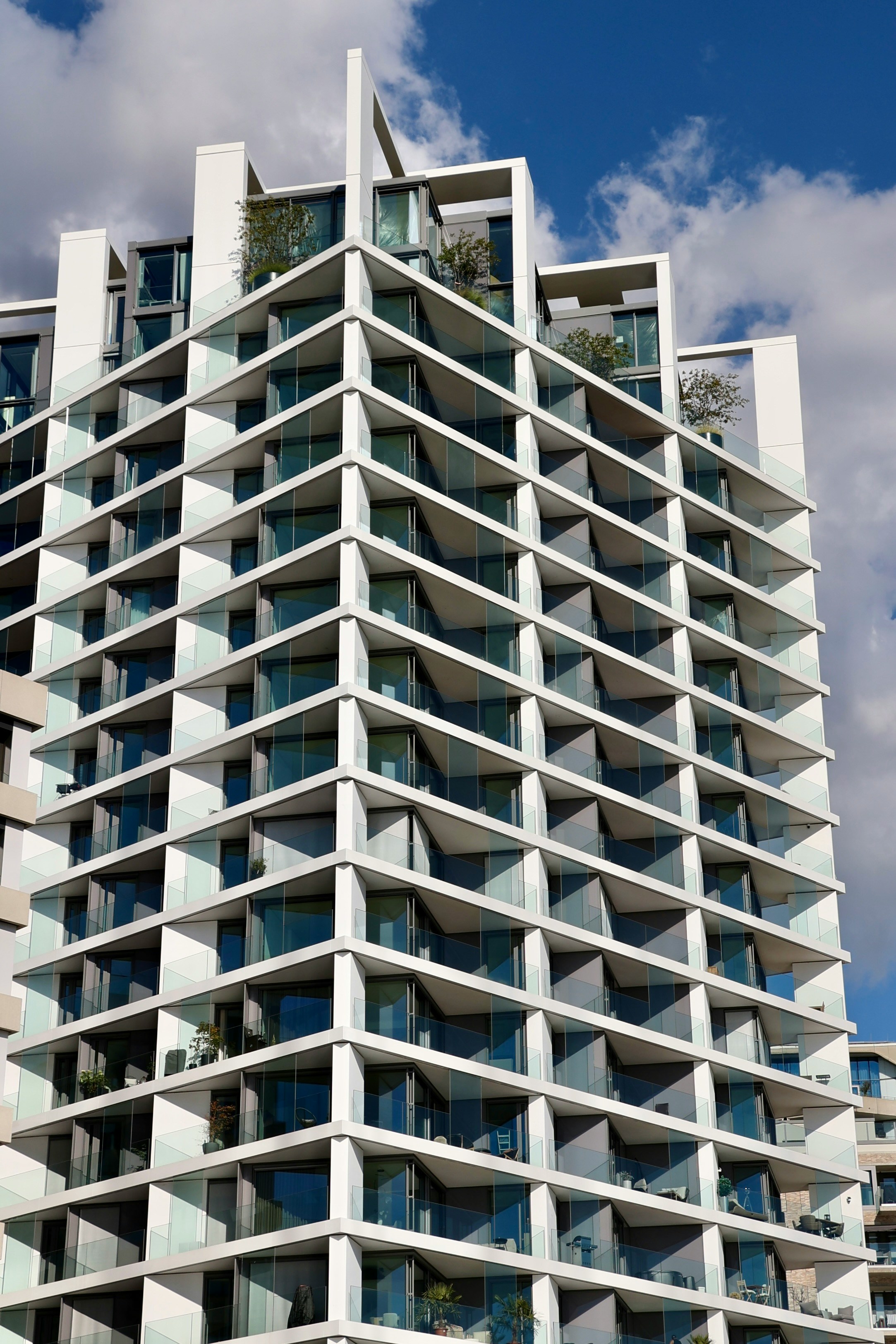 Modern white building with glass balconies against sky