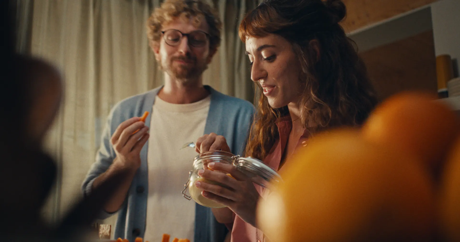 Pareja hablando en la cocina de su casa: qué seguros necesita una familia según su situación