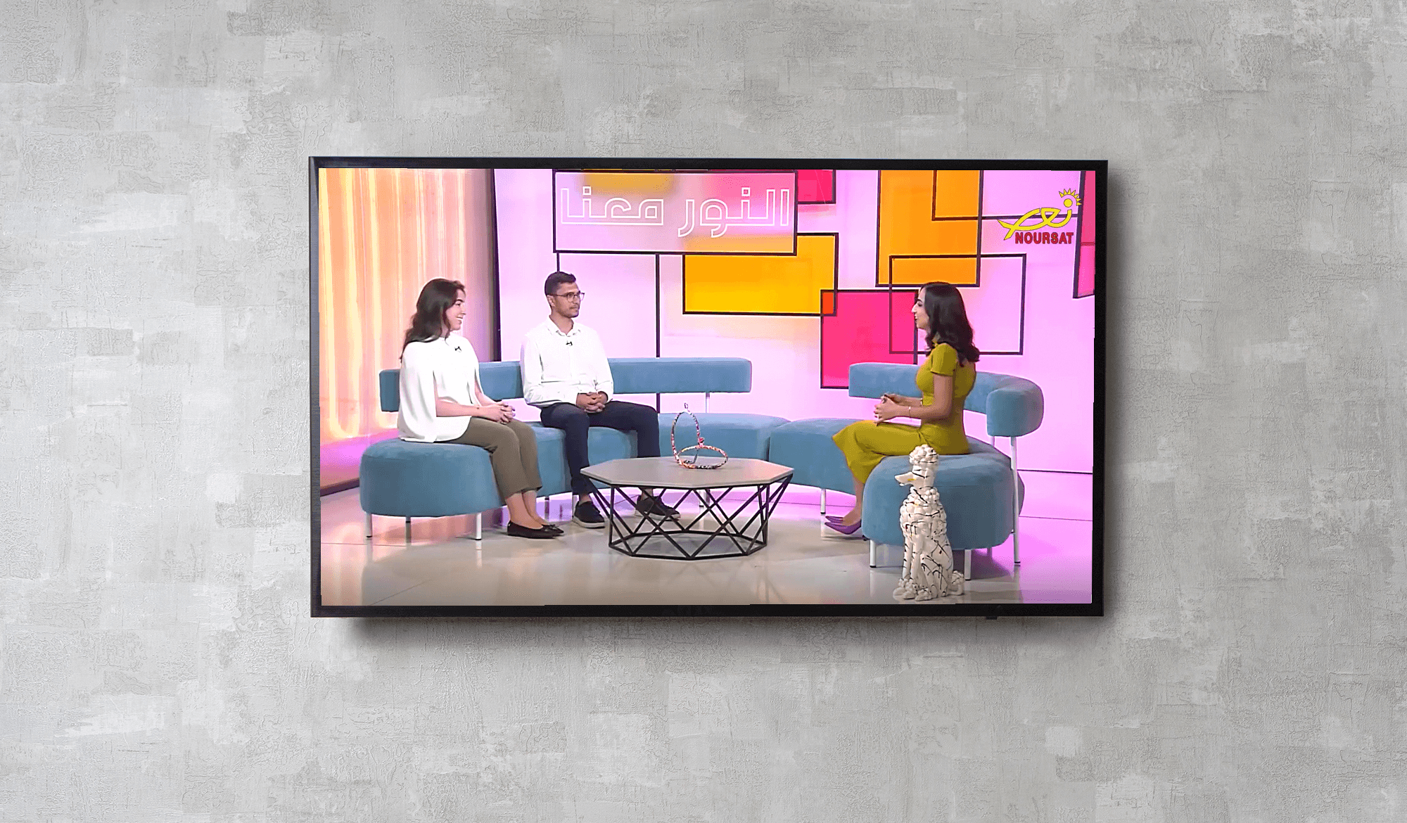 A TV showing a still from the Noursat interview with Youth4Governance (Y4G) alumni Kyra Chacra and Christian Ghassibe
