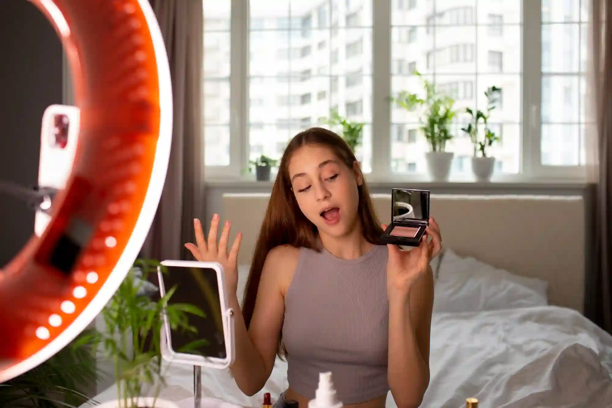 A young beauty vlogger is filming herself with a ring light.