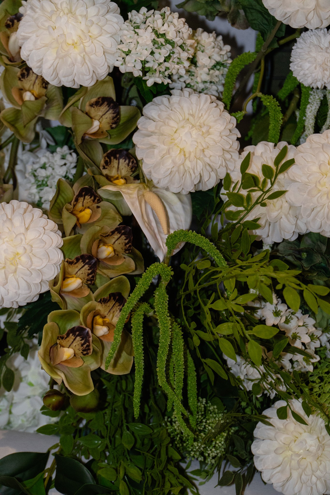 Close-up of a wedding flower arrangement with white blooms and green foliage.