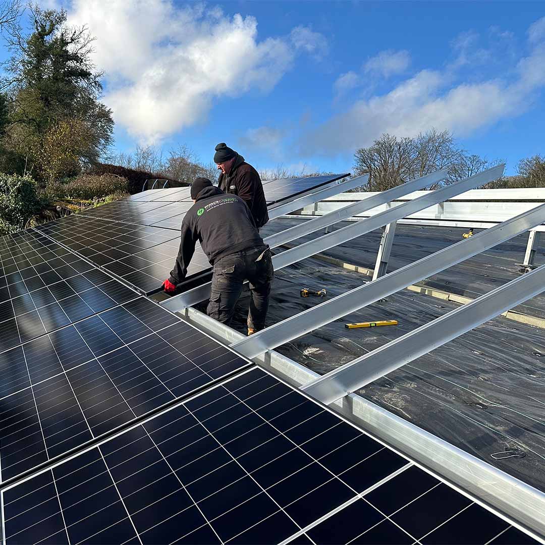 Pro-Teck engineers installing ground-mounted solar panels on a steep slope at Touchwood House, Puttenham.