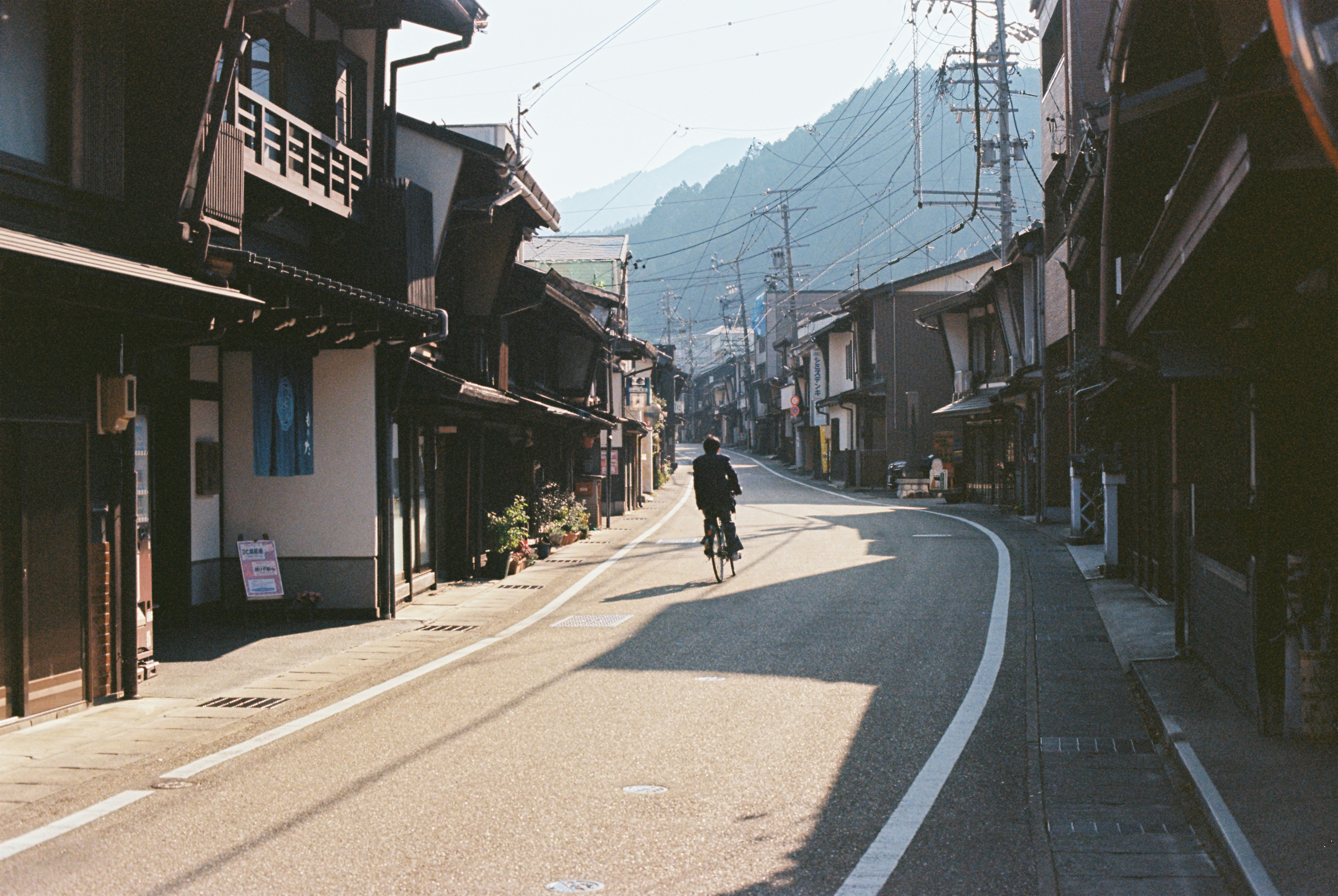 A person rides a bike down a quiet street.