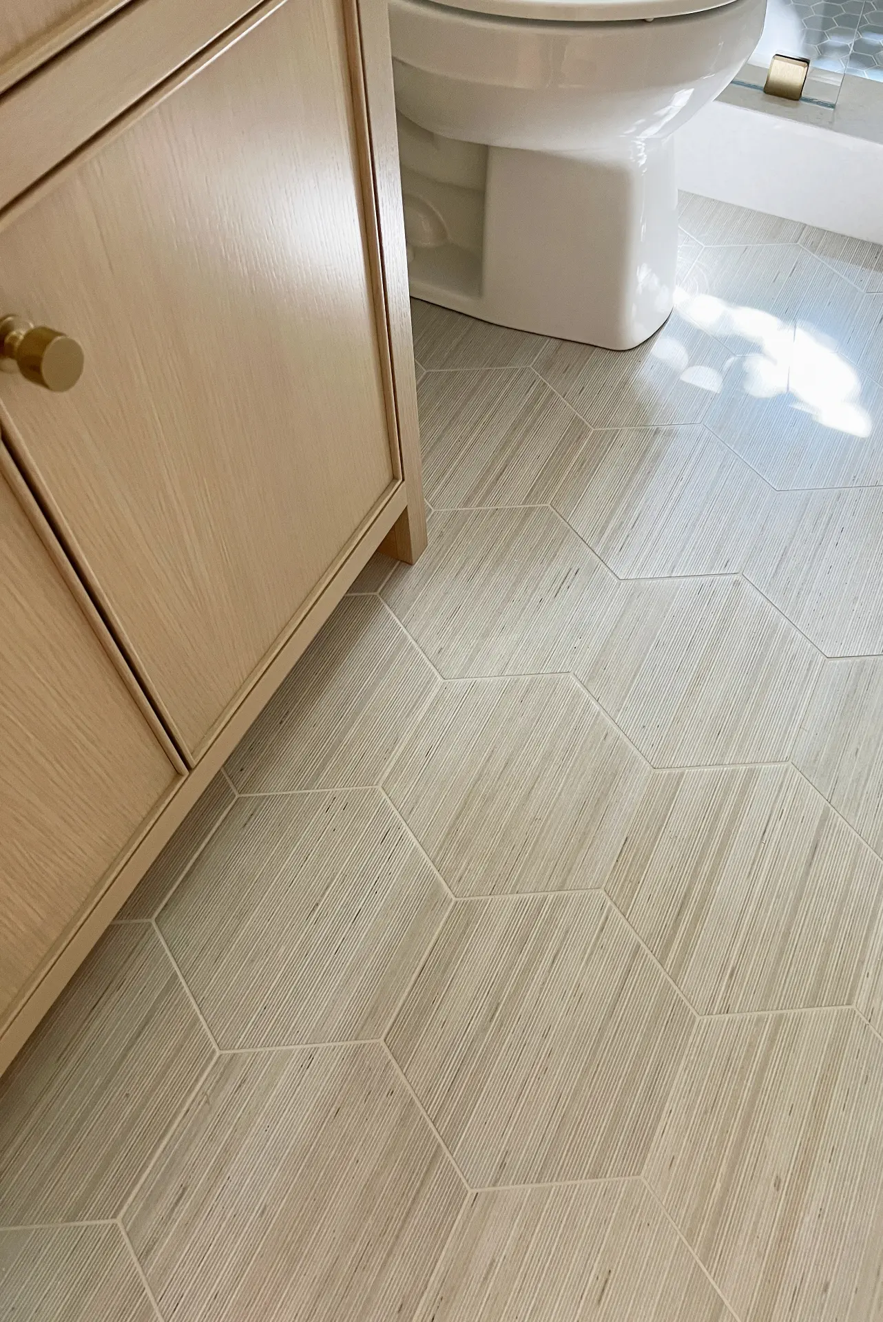 Close-up view of the tile flooring in the guest bathroom, highlighting the tile pattern and design in the Irvine Contemporary Coastal Remodel. Photo by Todd Huge.
