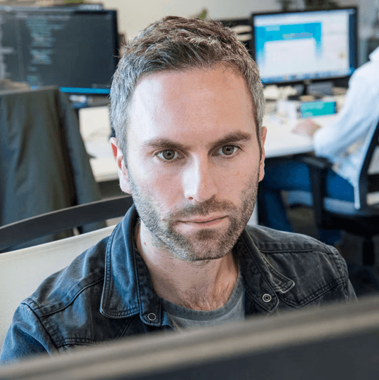 Male developer working at a large computer screen