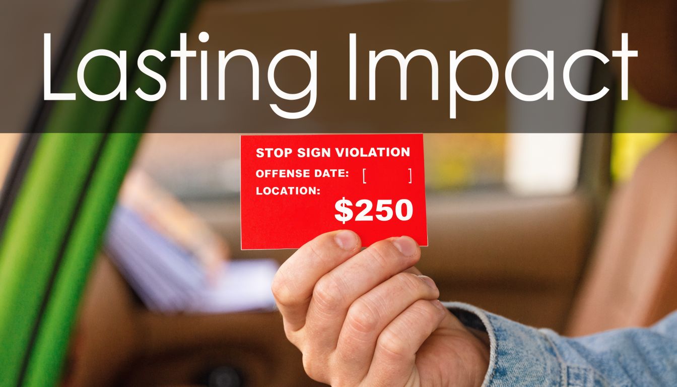 A close-up shot of a hand holding a red card detailing a two hundred fifty dollar stop sign violation.