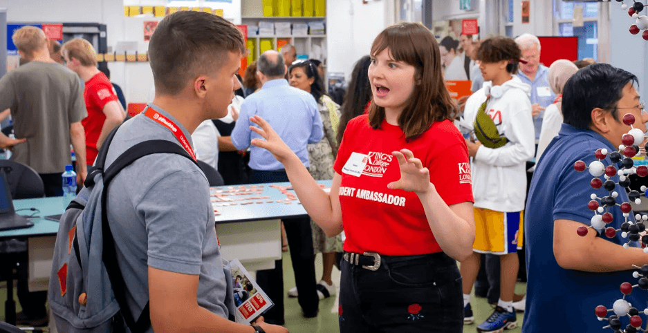 People standing near a table with drinks and items.
