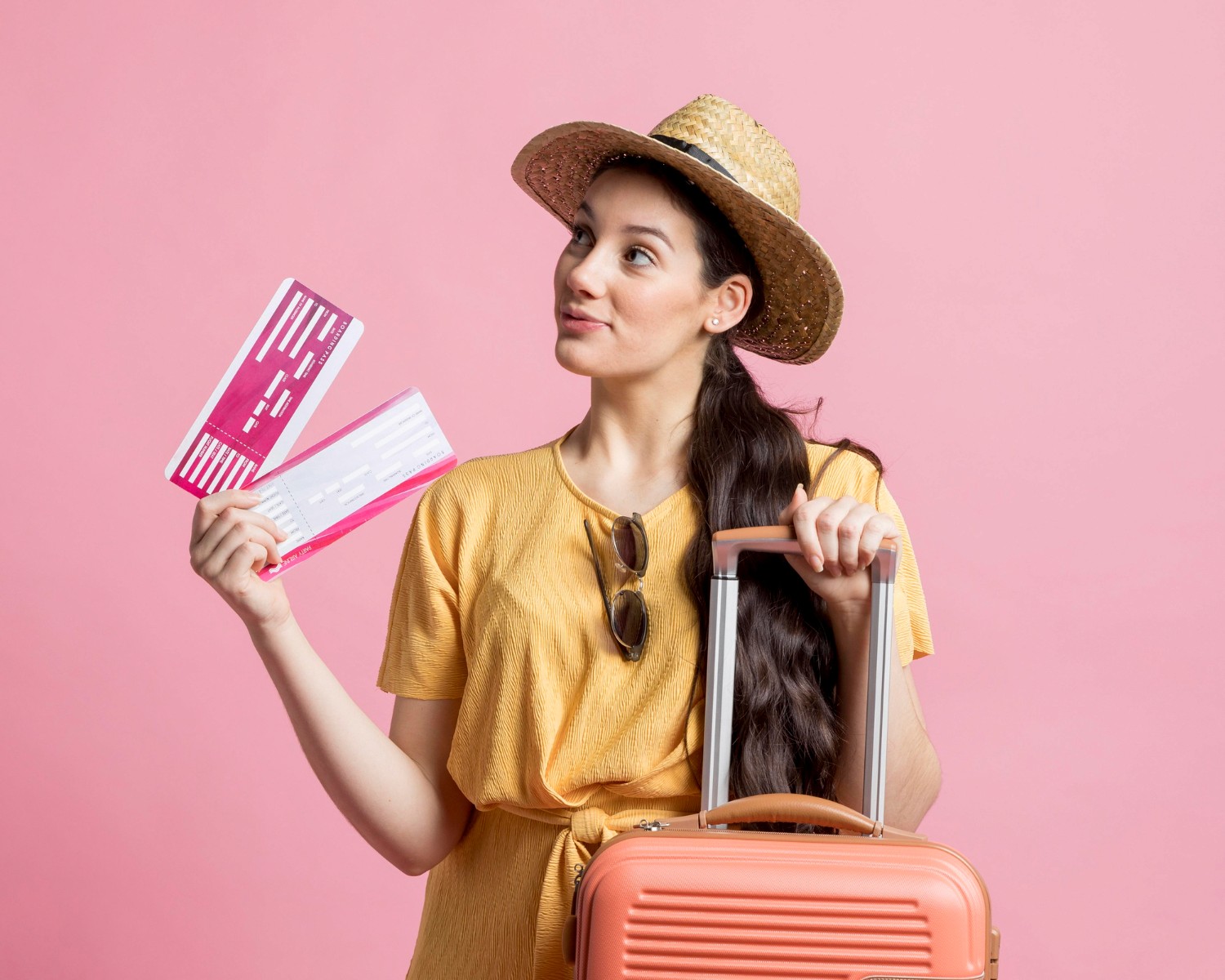 Woman with hat holding boarding pass and suitcase