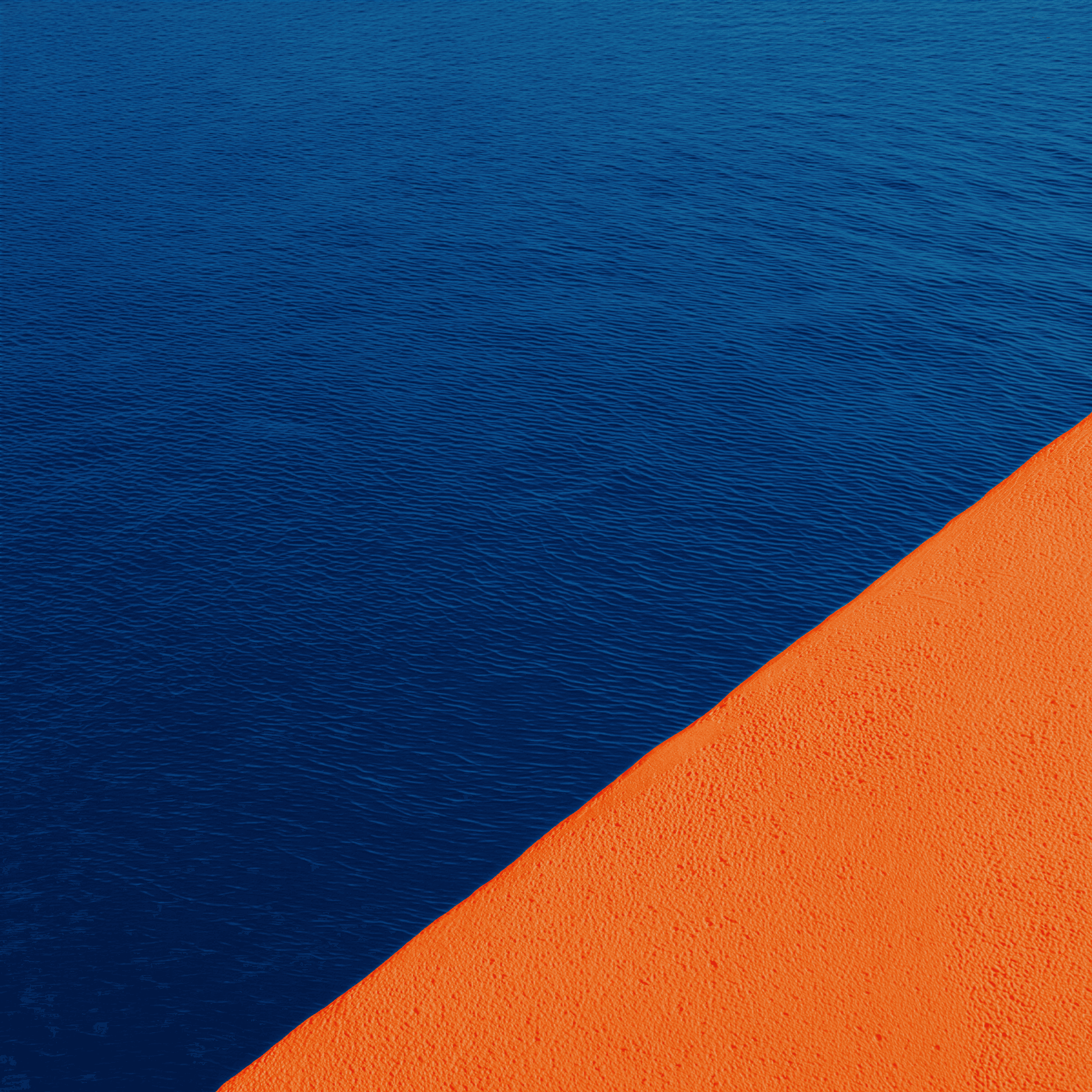 Dark blue undulating texture meets bright orange textured surface.