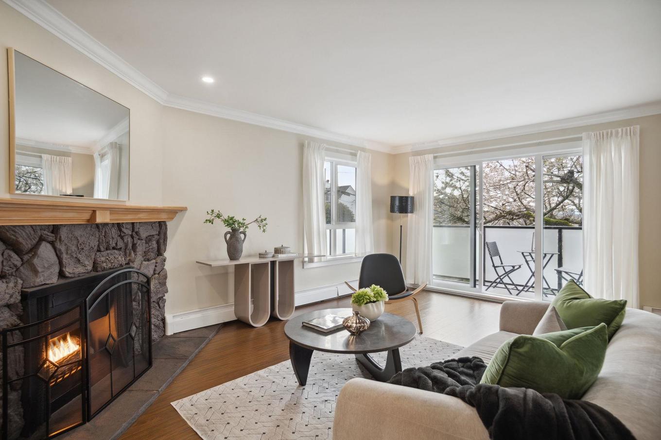 Cozy living room featuring a fireplace, modern furniture, and natural light from large windows.