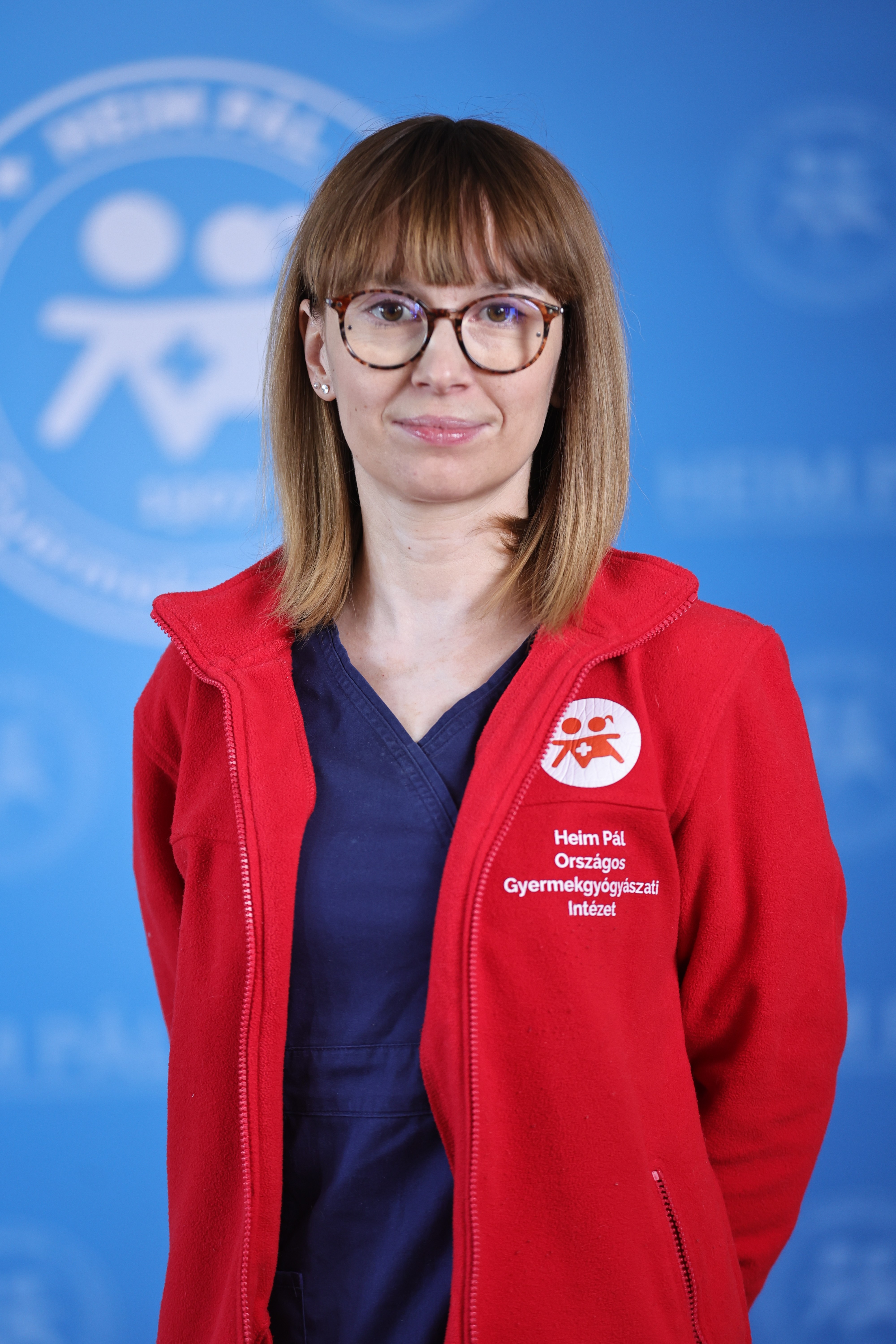 Szemüveges szőke nő piros kardigánban