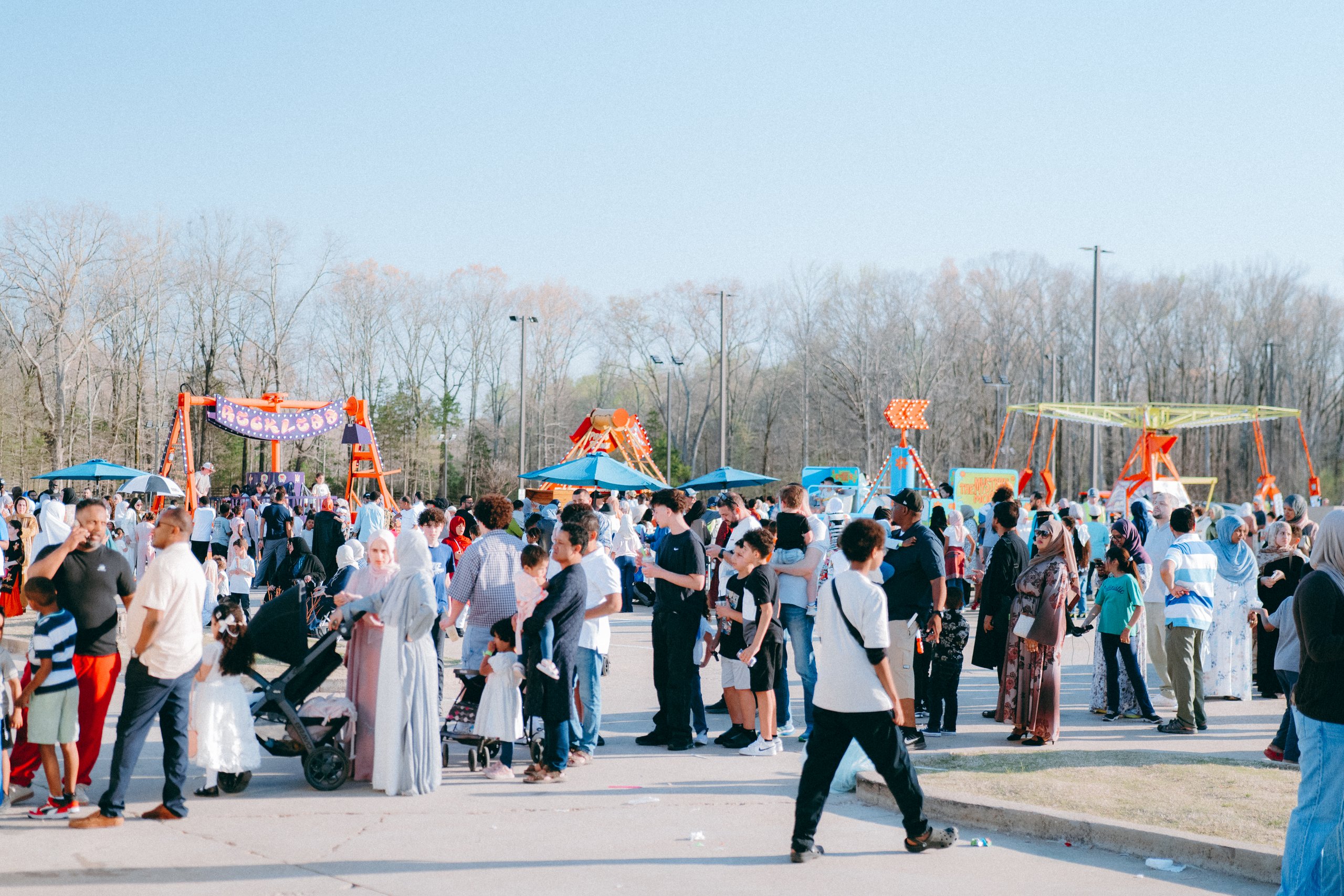 Crowds walk past the rides at the Eid Festival in Memphis
