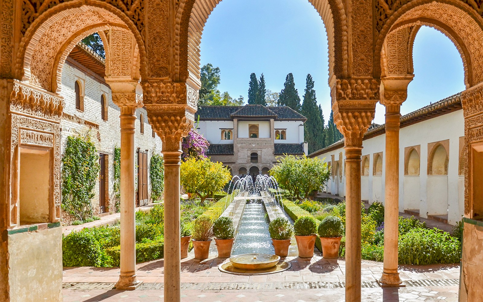 Generalife Gardens courtyard with ornate arches and central fountain in Granada.