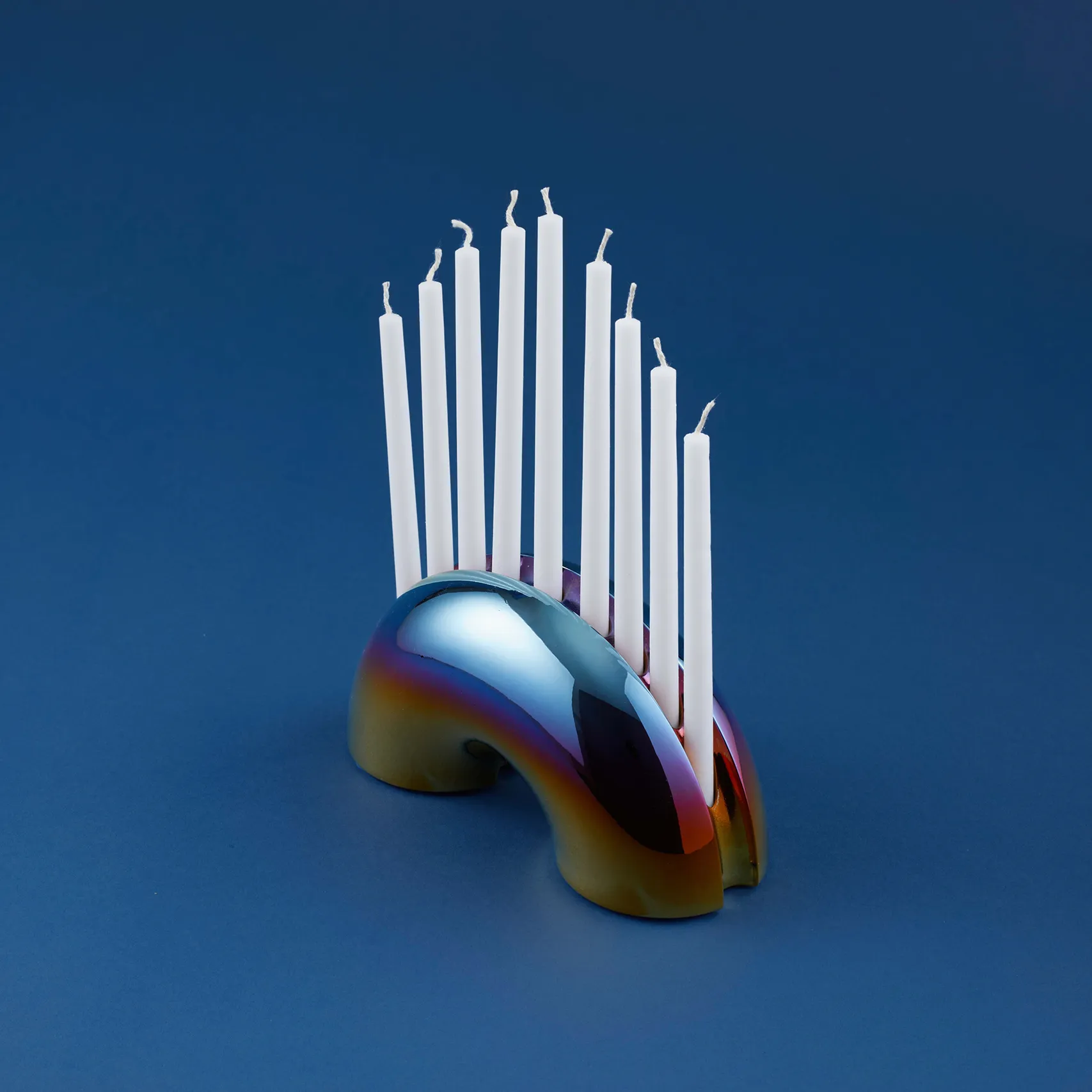 Iridescent Nosh Menorah with white candles shown from a three-quarter side angle