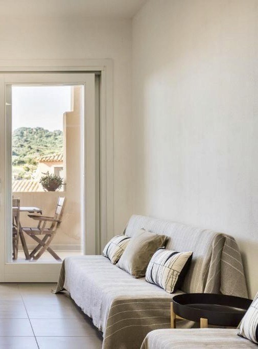 Soggiorno con divano e vista verso l’esterno del Quadrilocale Shardana Superior