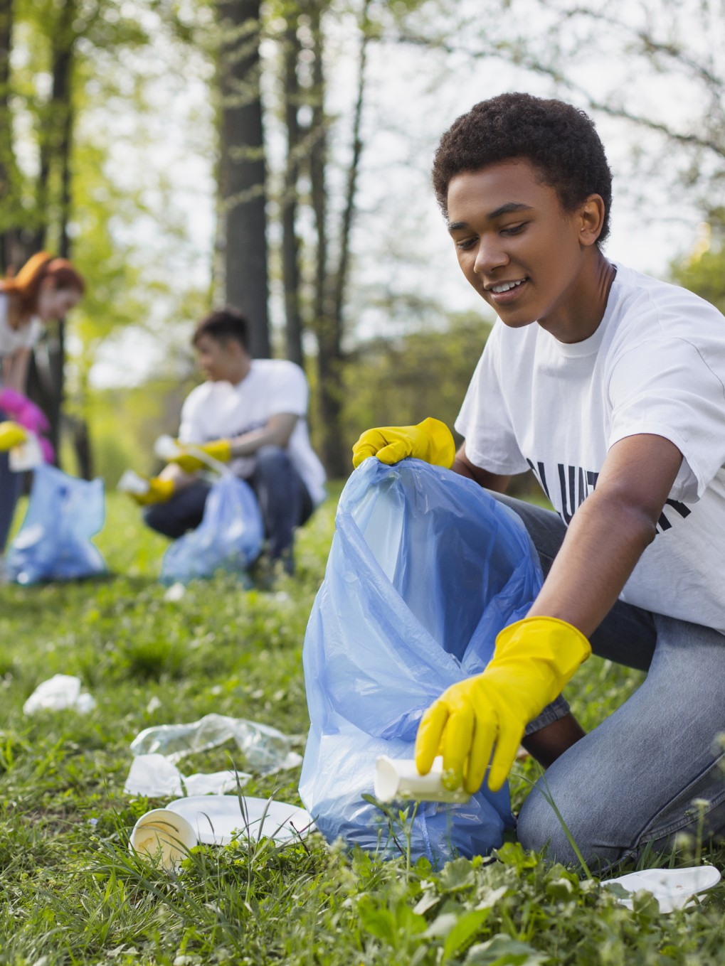 boy picking up trash outdoors