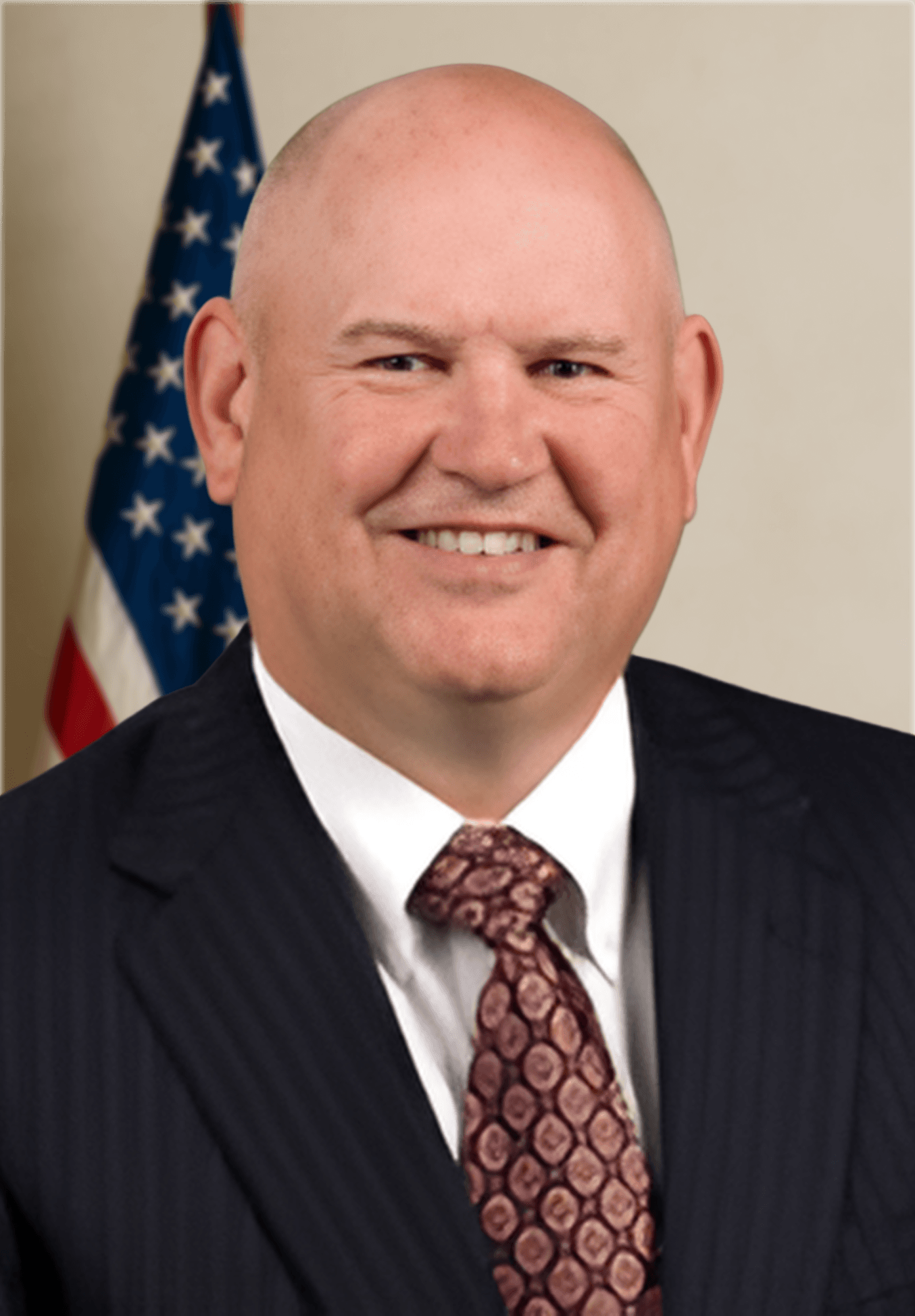man sitting facing silver MacBook inside room