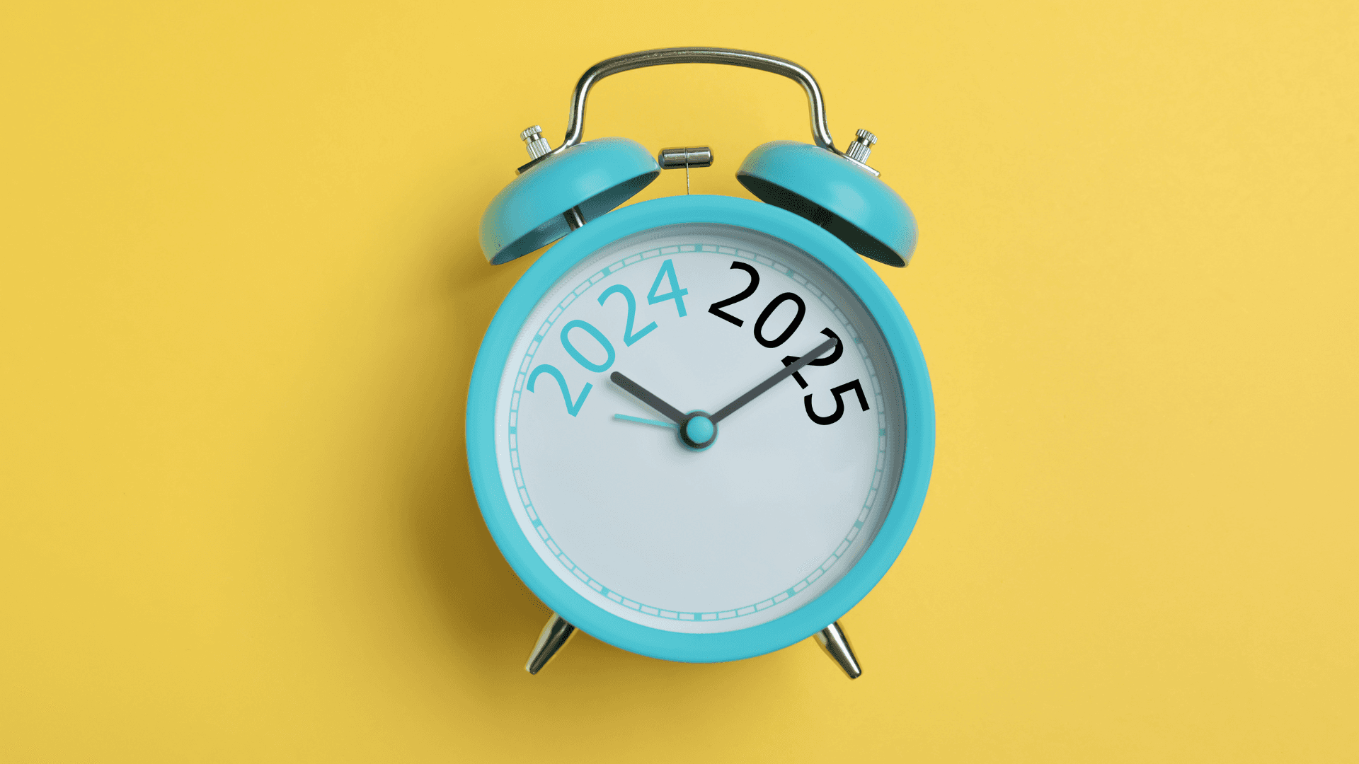 Blue alarm clock with the years 2024 and 2025 printed on a yellow background.