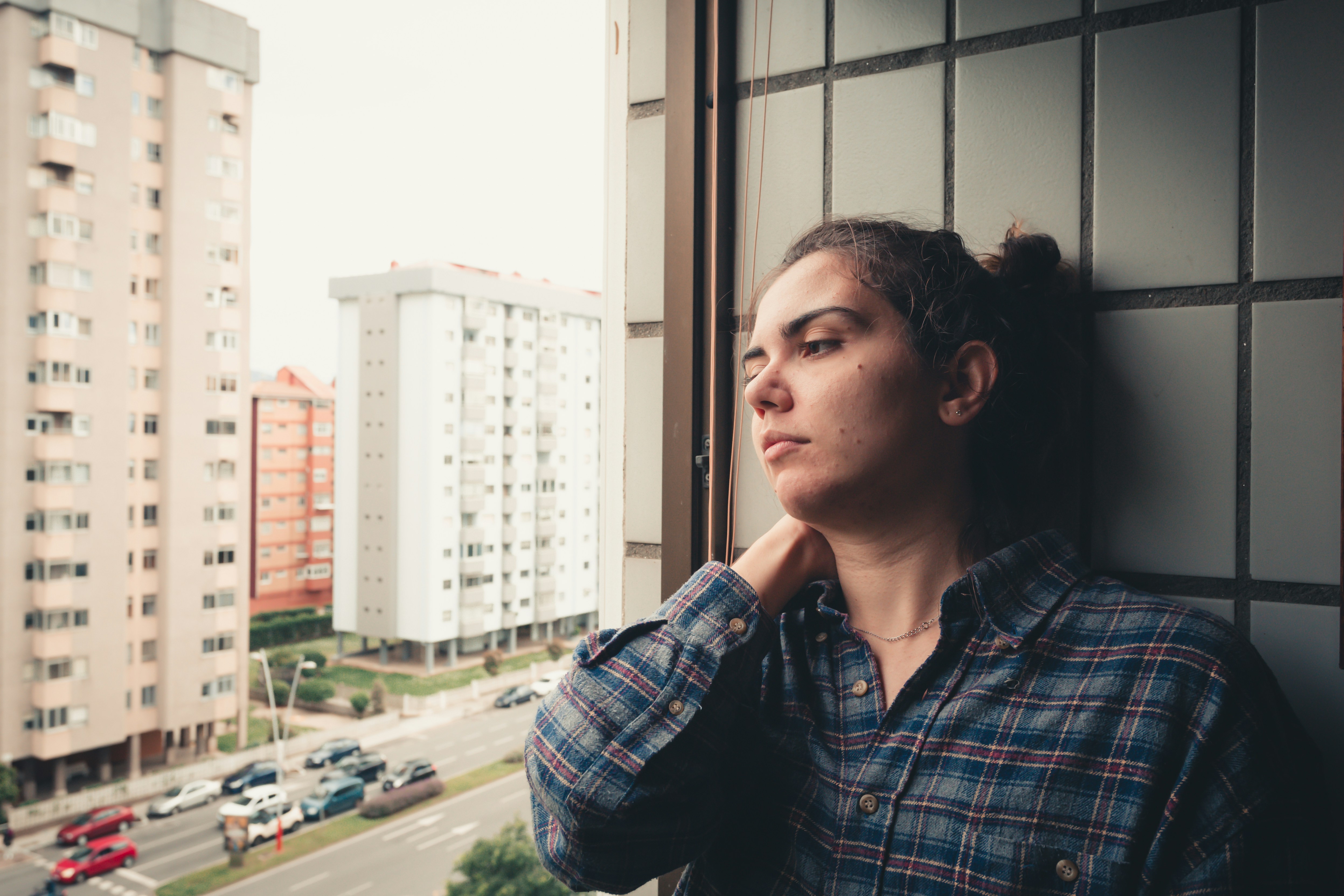 sad-looking woman staring out an office window
