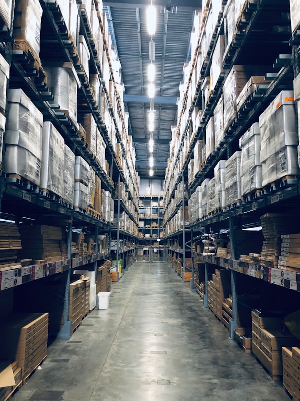 A long aisle inside a distribution warehouse lined with tall pallet racking