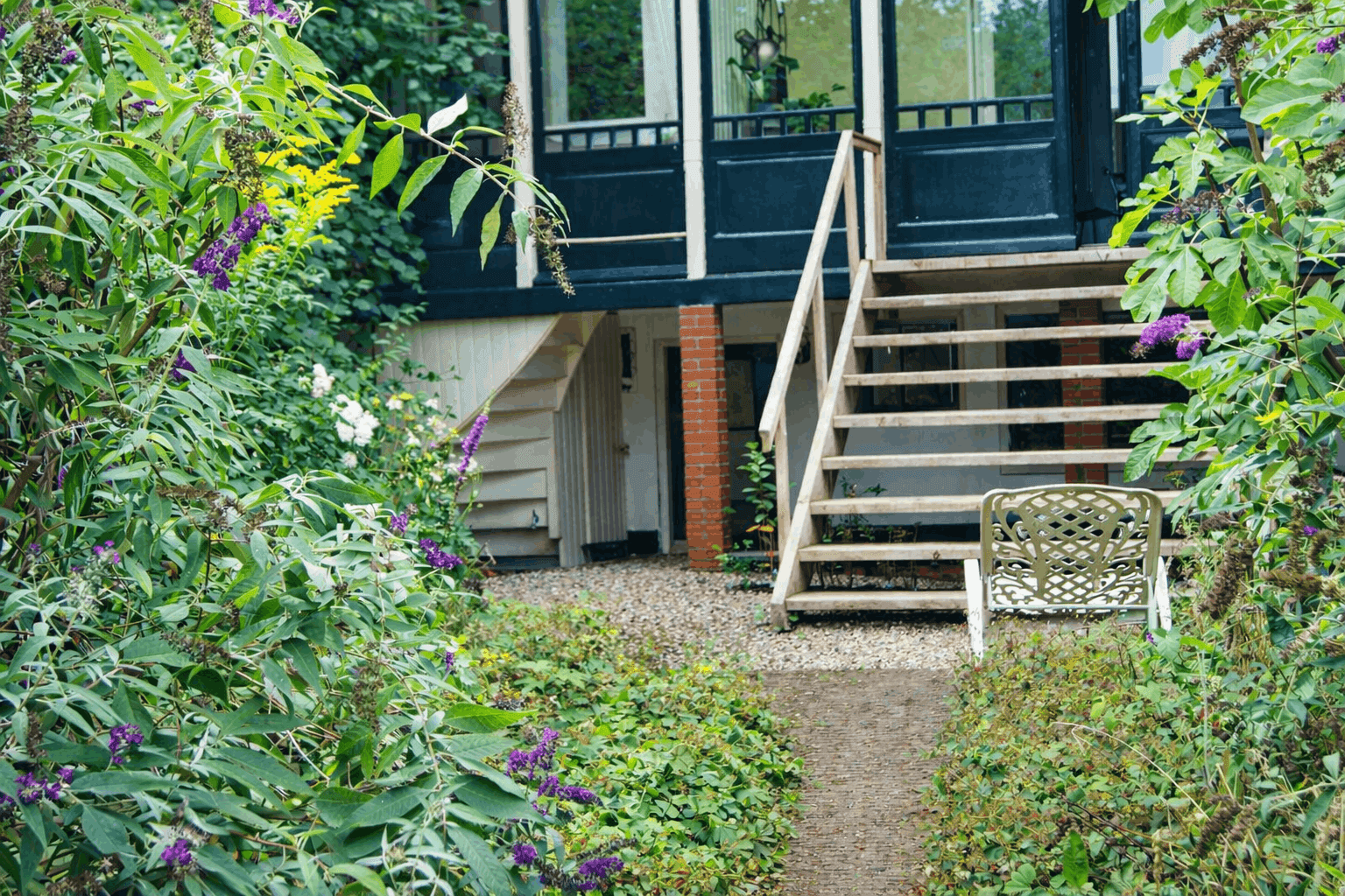 Een kleurrijke tuin met de ingang naar de B&B van de Impact Stay