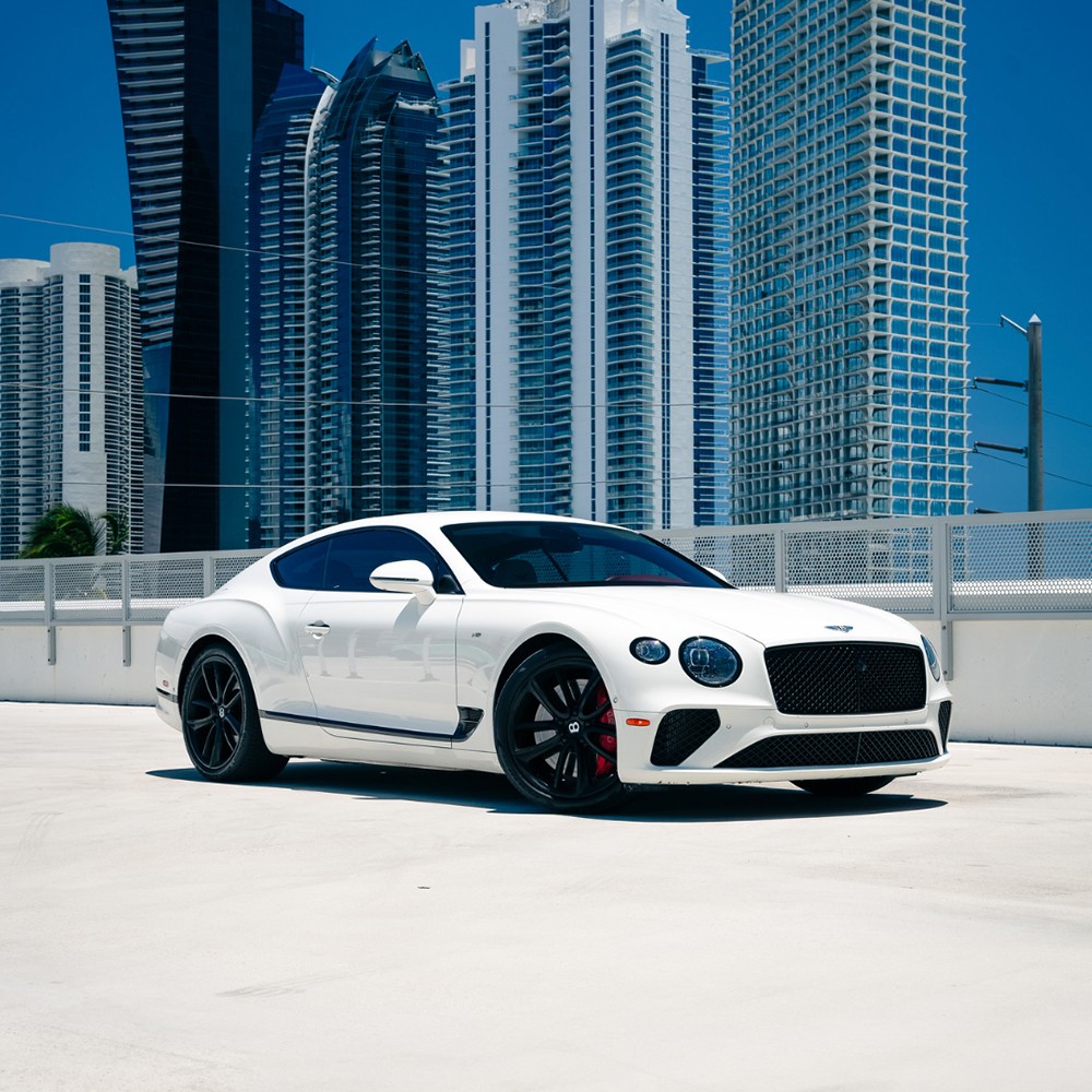 Bentley Continental GT parked on a rooftop in Miami with city skyline in the background