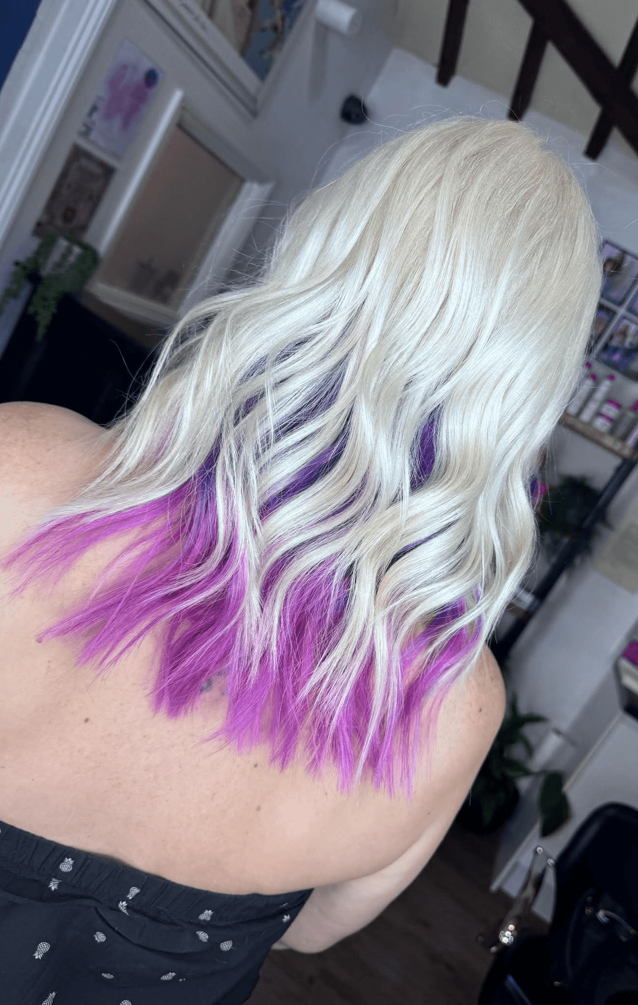 Woman with long wavy blonde hair with purpler highlights at Inspire Studio Salon