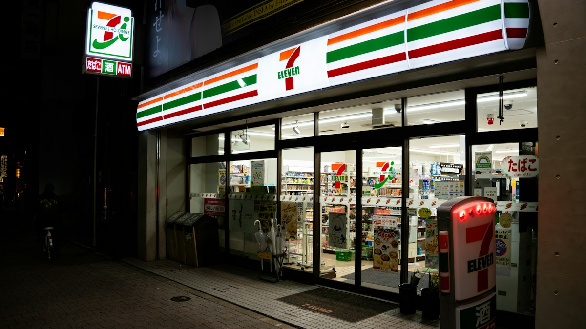 A 7-Eleven convenience store front at night in Japan
