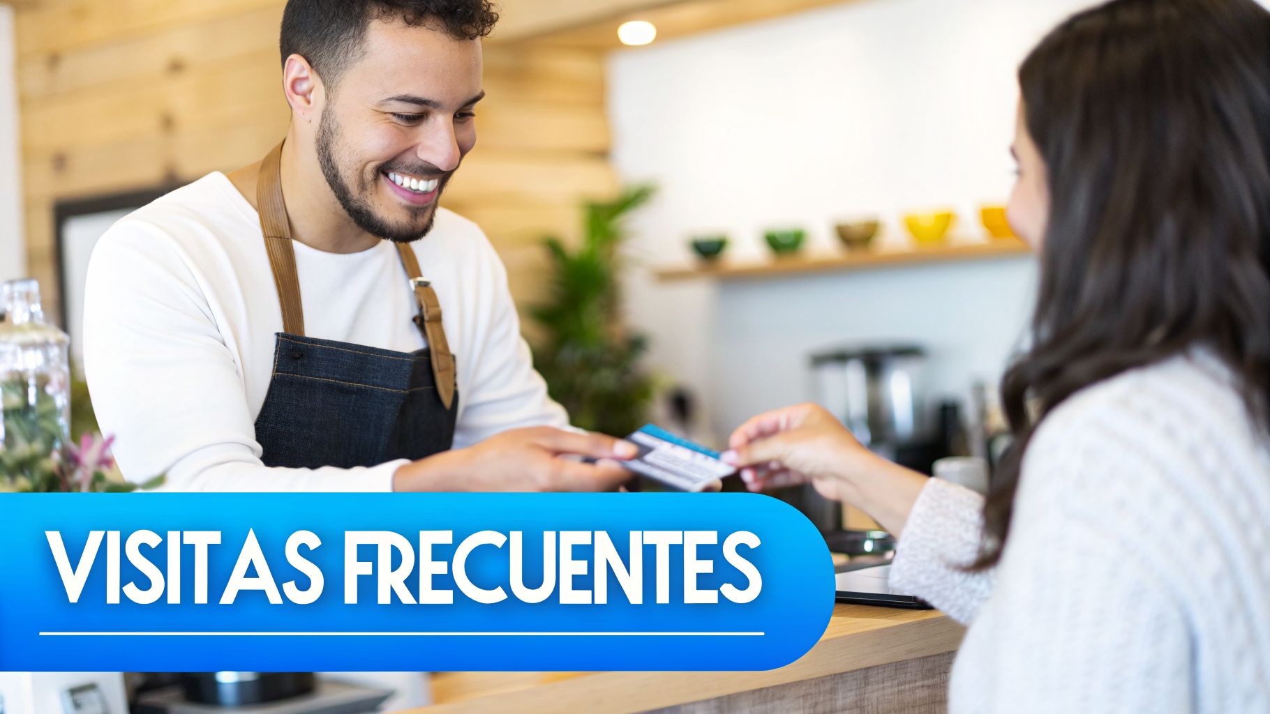 Un barista sonriente entrega una tarjeta de lealtad a una clienta en un mostrador de cafetería.
