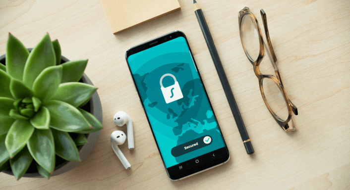 Smartphone showing security lock icon on desk.