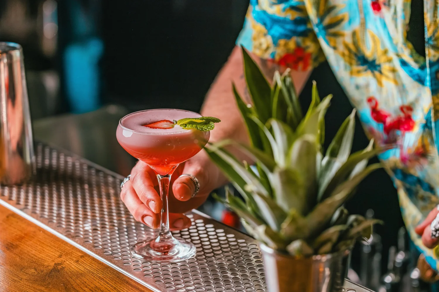 Bartender service a pink strawberry cocktail