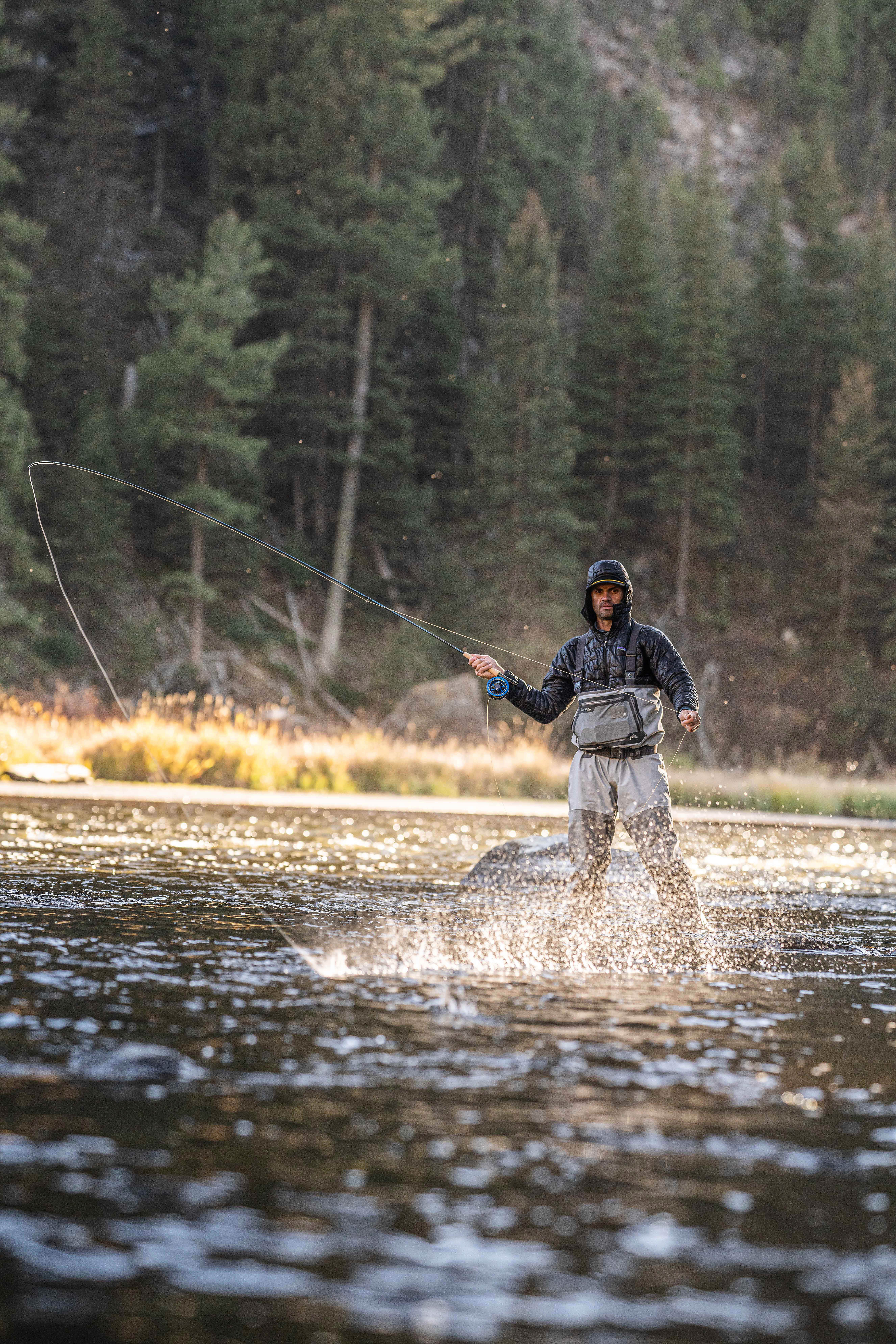 fly fisherman roll casting in sunlight