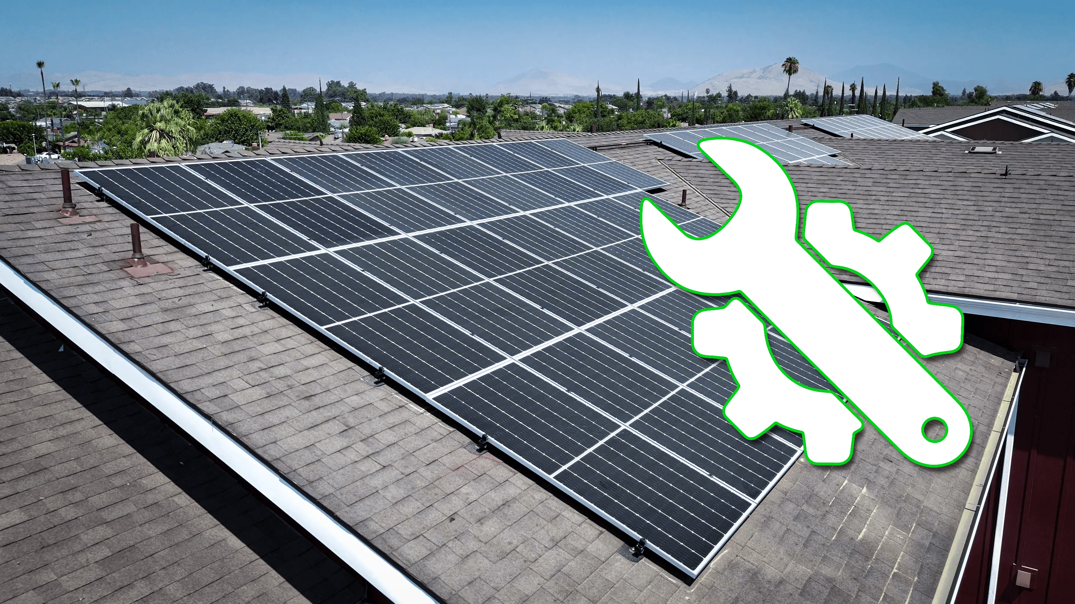 Rooftop solar panel system on a residential home with an overlaid wrench and gear icon symbolizing repair and maintenance.
