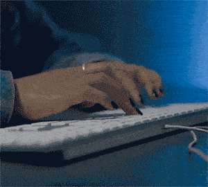 Plan rapproché des mains tapant sur un clavier pour saisir une référence Pop Culture dans PopCorn Garage lors d'une soirée d'entreprise.