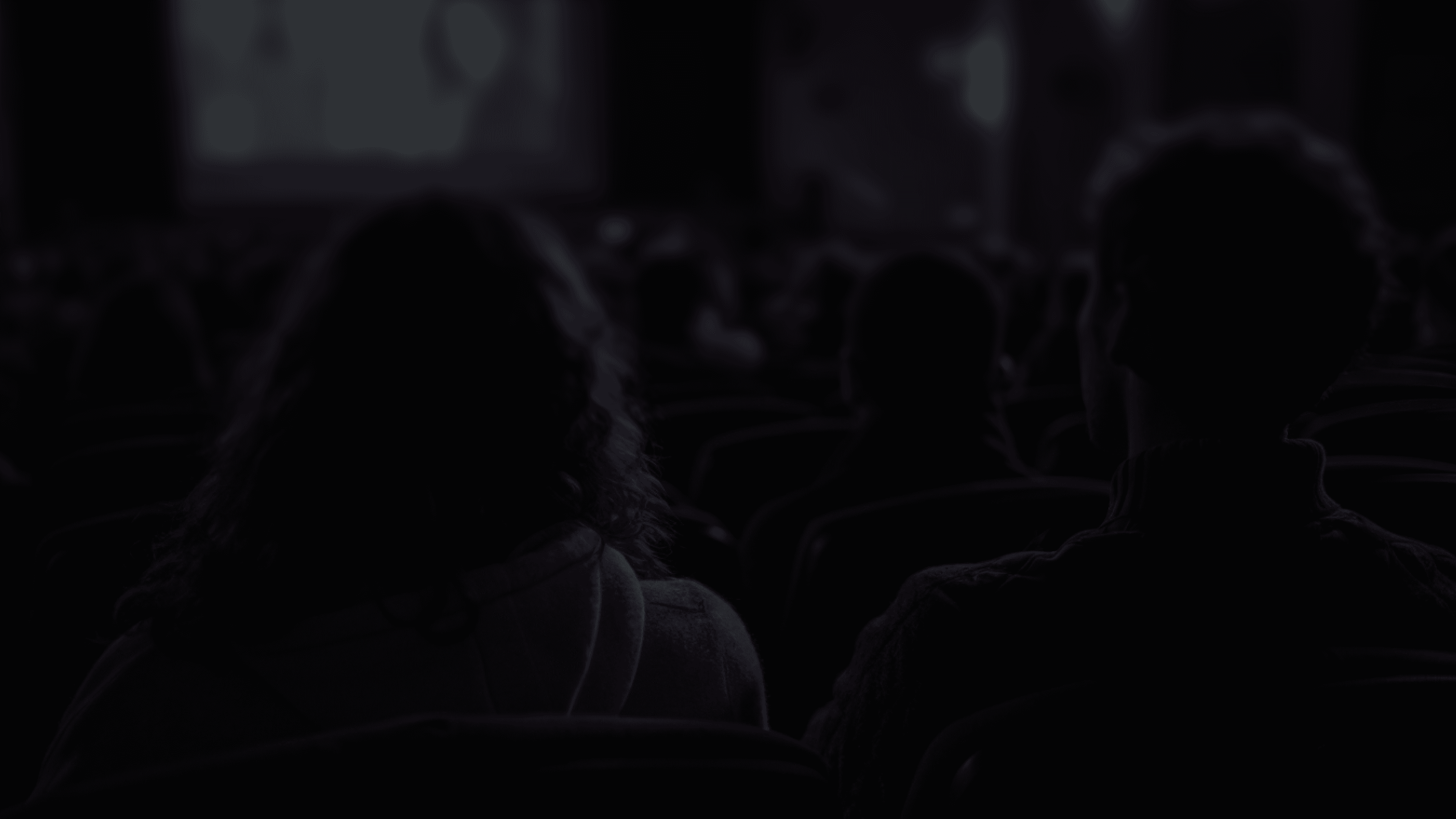 Audience in cinema theater watching film trailer, representing maximized audience engagement for film marketing with SocialSense 360