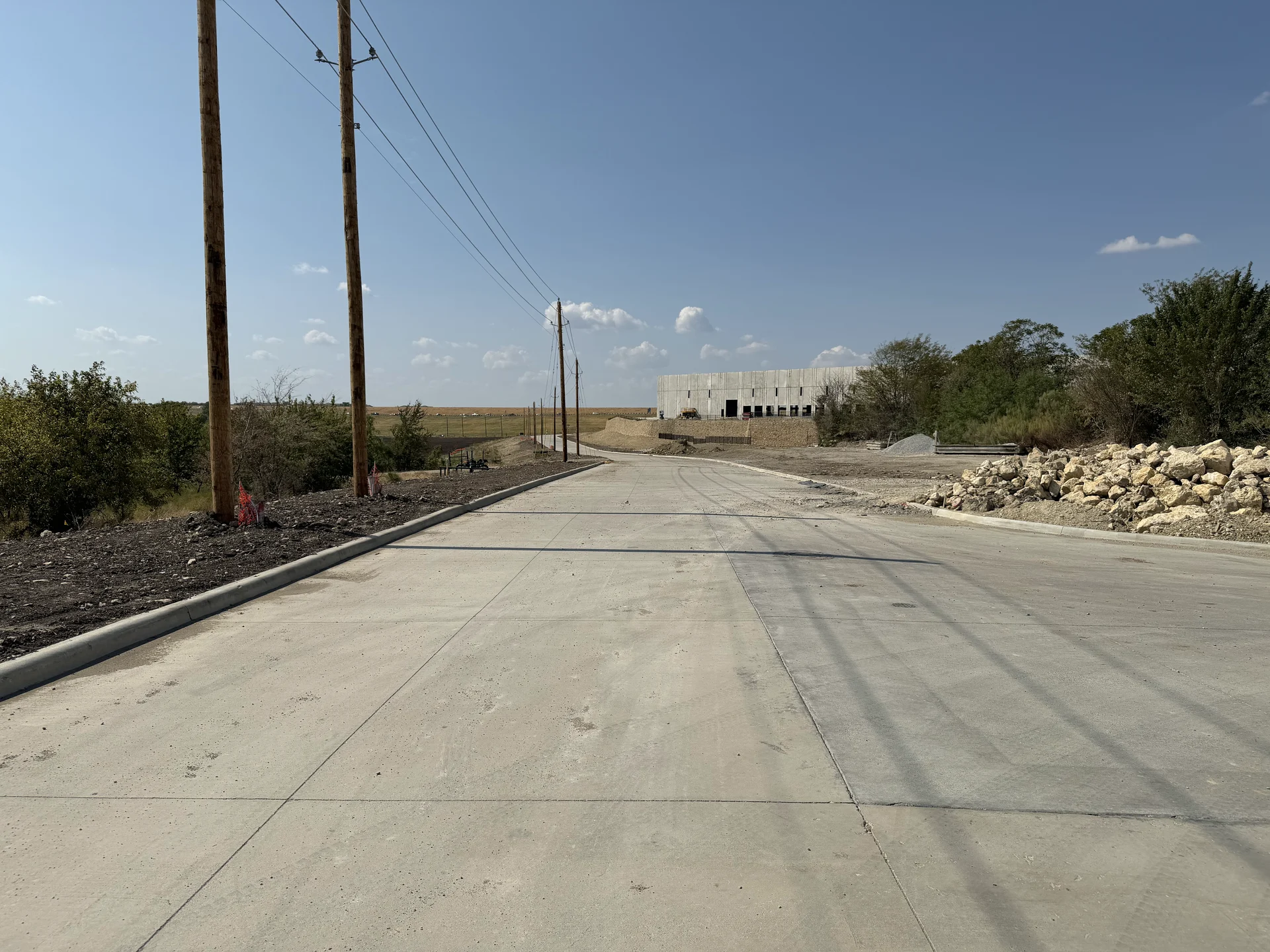 Commercial access road, utility poles and an industrial building in Texas