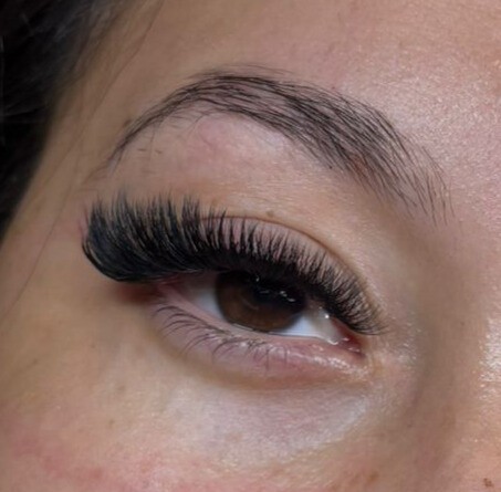 Extension de cils volume sur œil marron – cils fournis et recourbés pour un regard intense, réalisée par technicienne experte en beauté du regard.